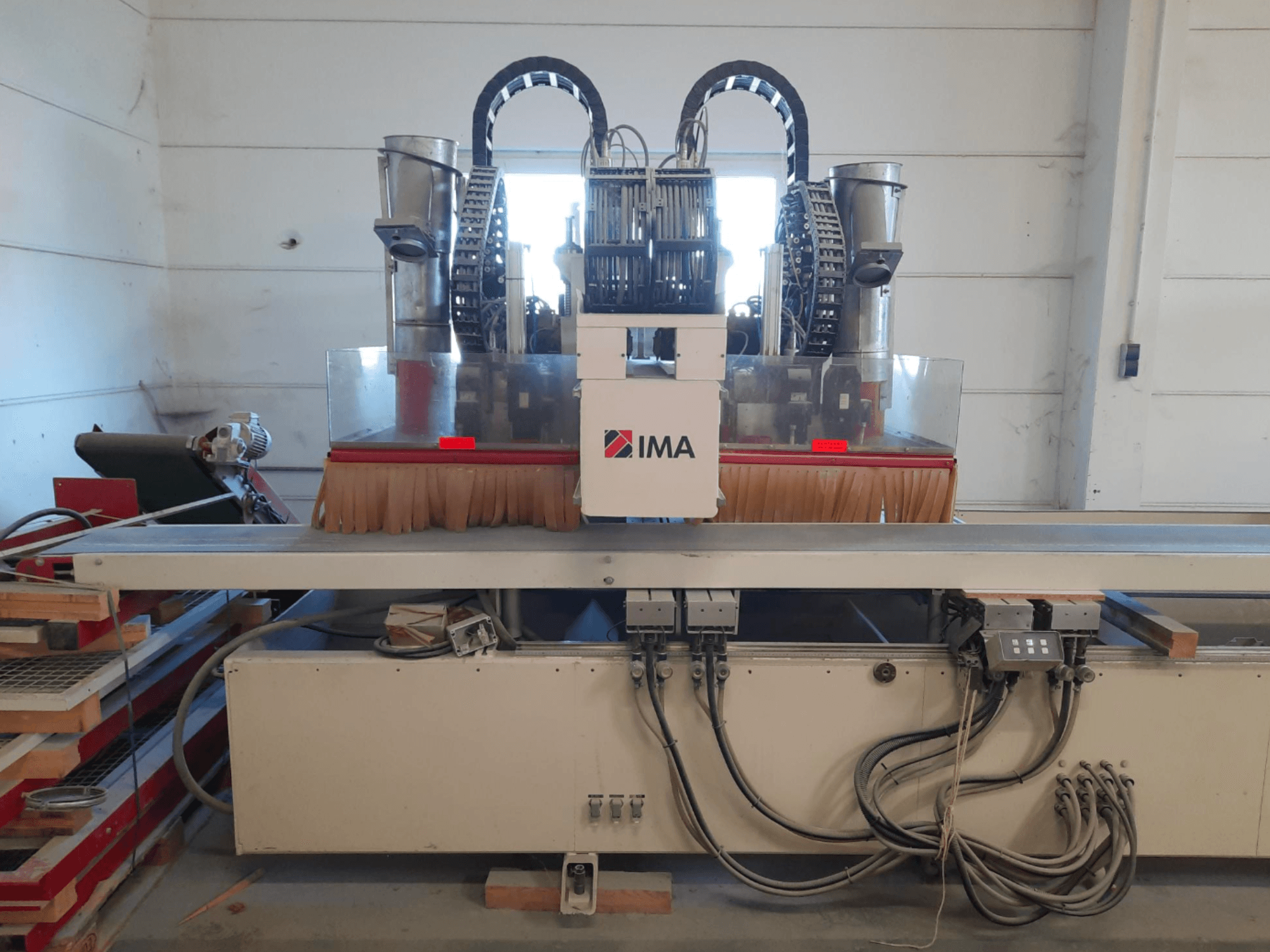Centro de usinagem de madeira CNC IMA BIMA 610 V visto de frente, apresentando escovas, comandos e uma mesa de trabalho.