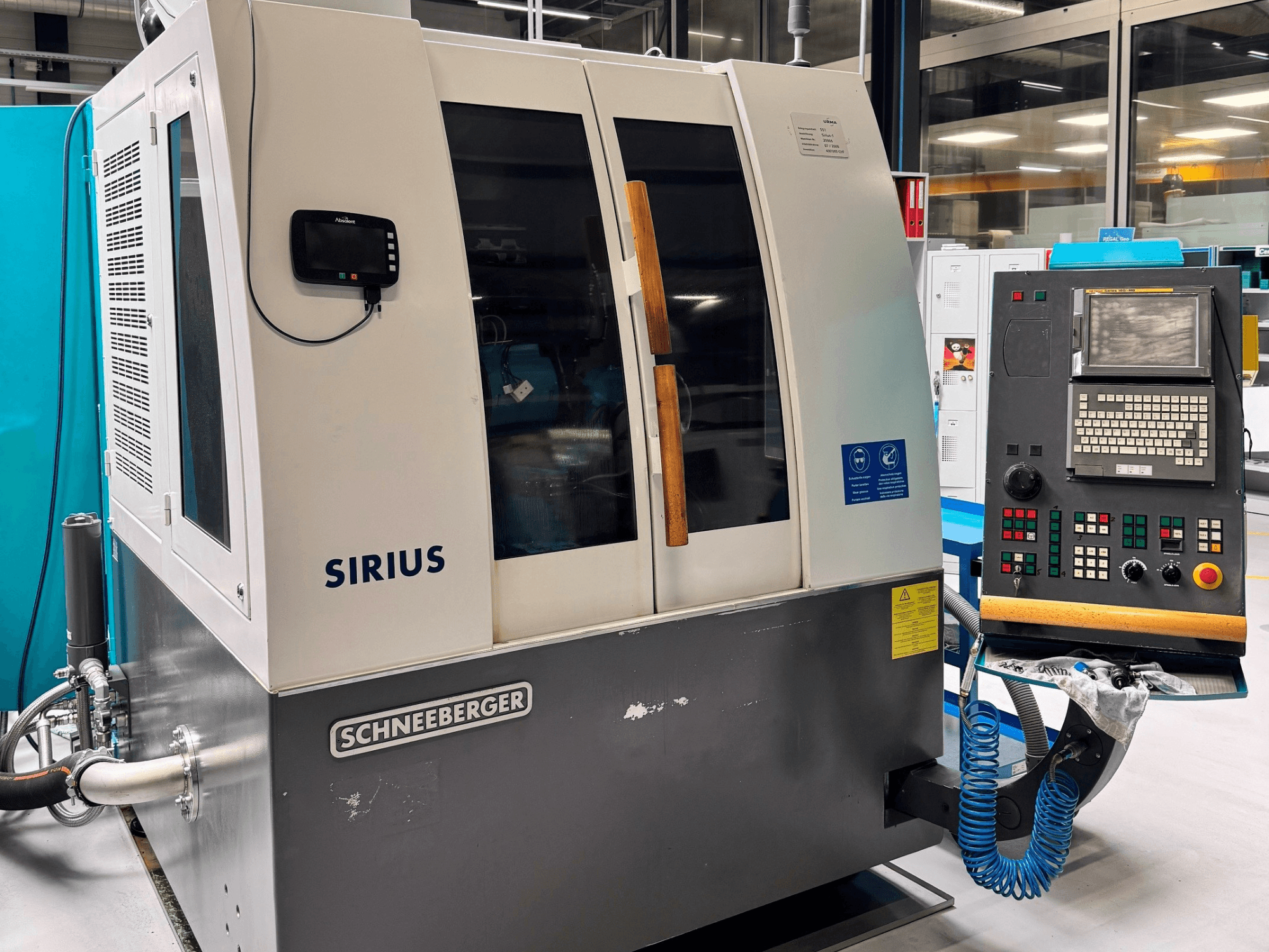 Máquina de retificação plana Schneeberger Sirius HPM, vista lateral, mostrando o painel de controlo e os indicadores de funcionamento.