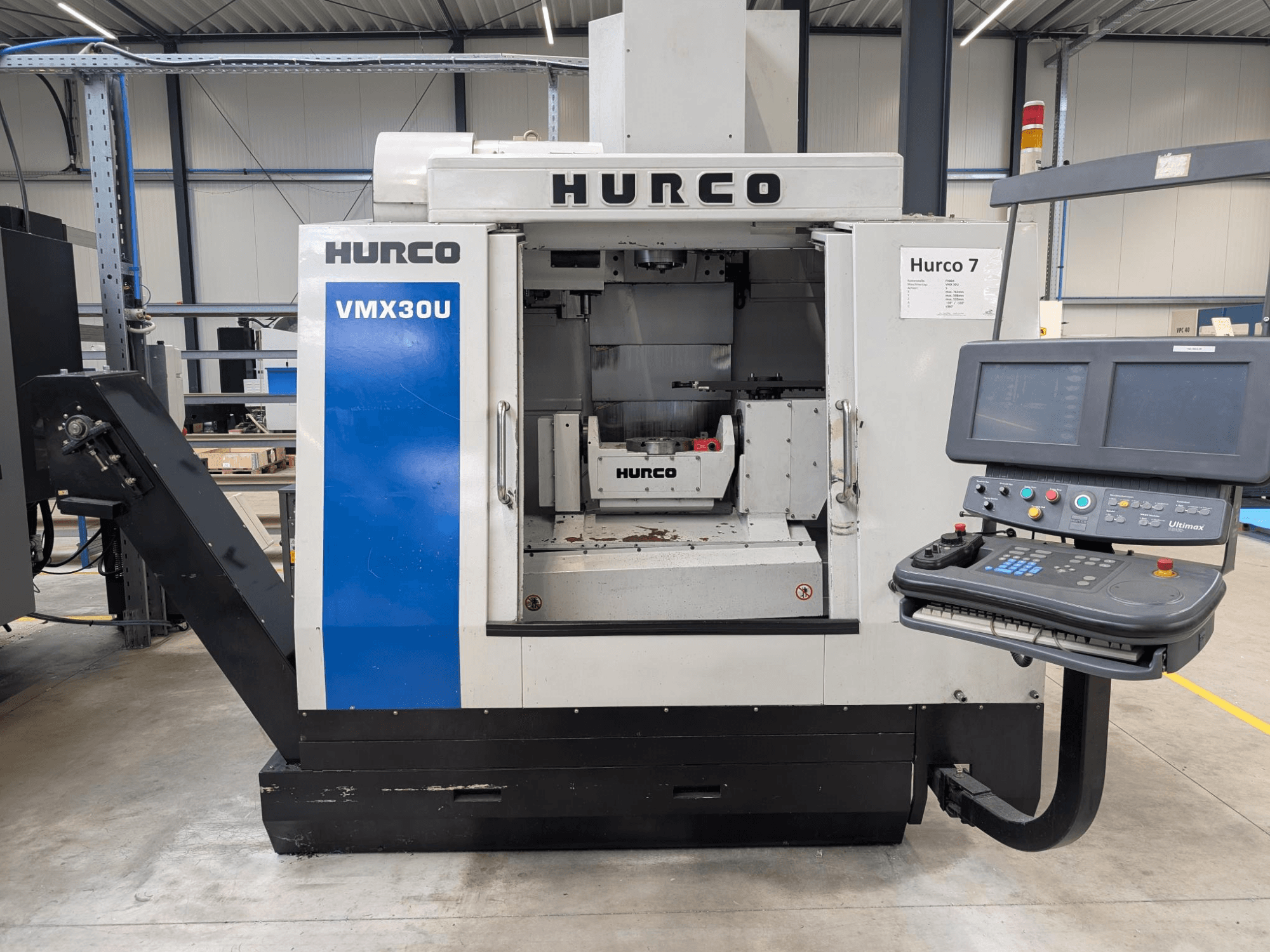 Máquina CNC Hurco VMX30U em vista frontal com painel de controlo; possui um interior espaçoso e uma interface de controlo de precisão.