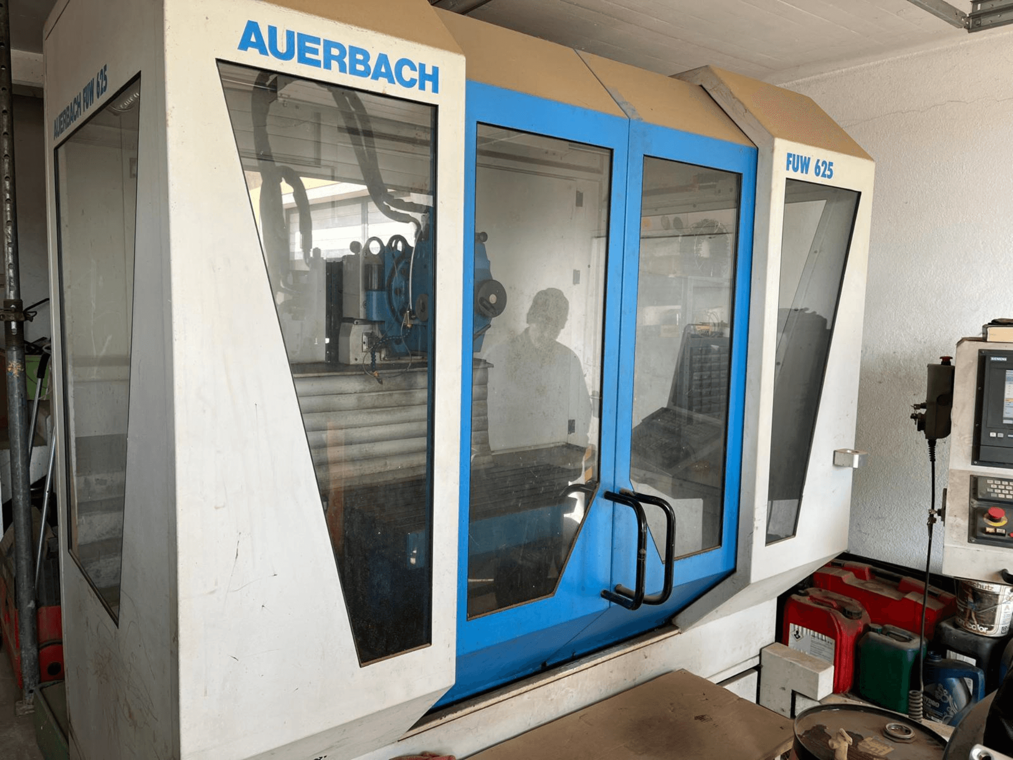 Centro de maquinação universal Auerbach FUW 625 em vista lateral, com painéis de vidro e um painel de controlo à direita.