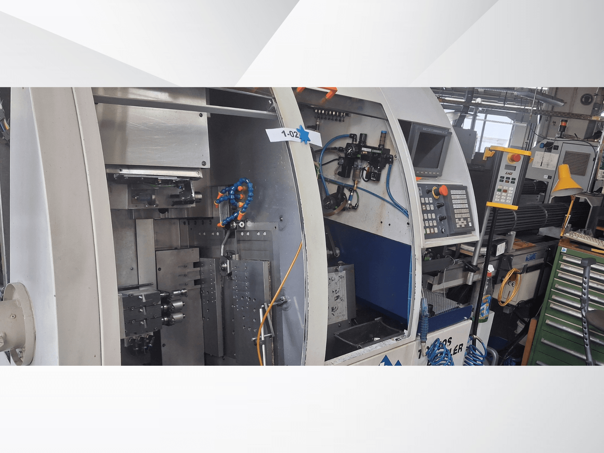 Máquina de tornear tipo suíço TORNOS DECO 2000-10, vista frontal mostrando o painel de controlo, mecanismo de rotação e configuração interna.