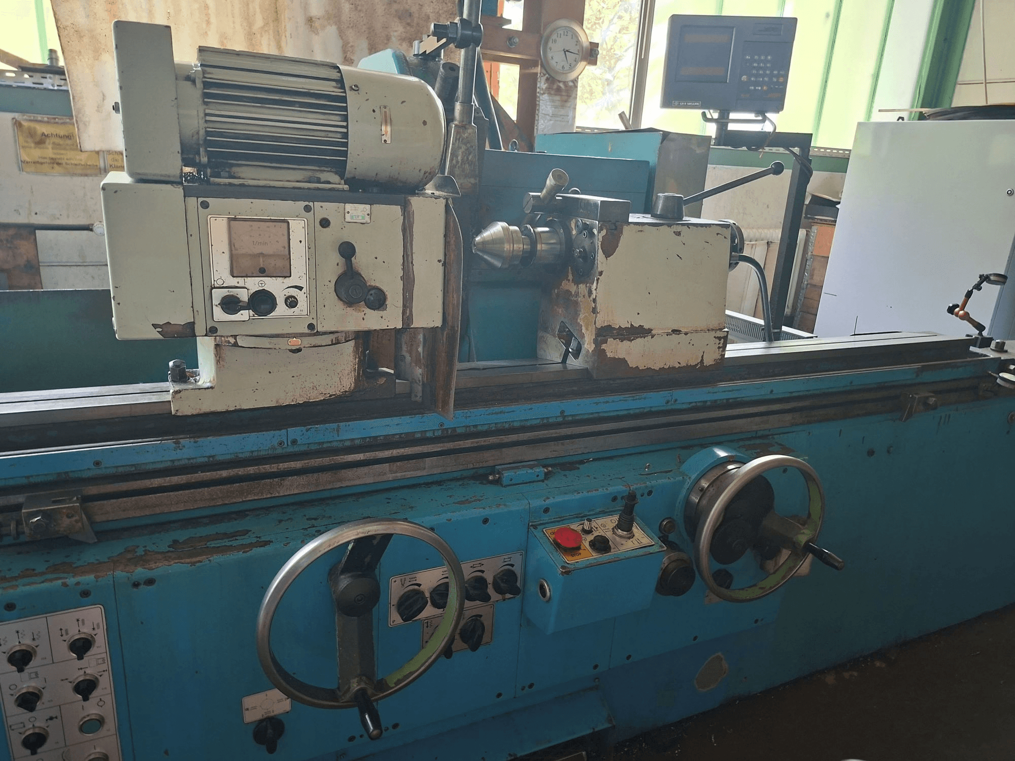Retificadora cilíndrica Cetos BHU 50 A x 2000, vista frontal, mostrando os comandos, o motor e a área de trabalho num ambiente de oficina.