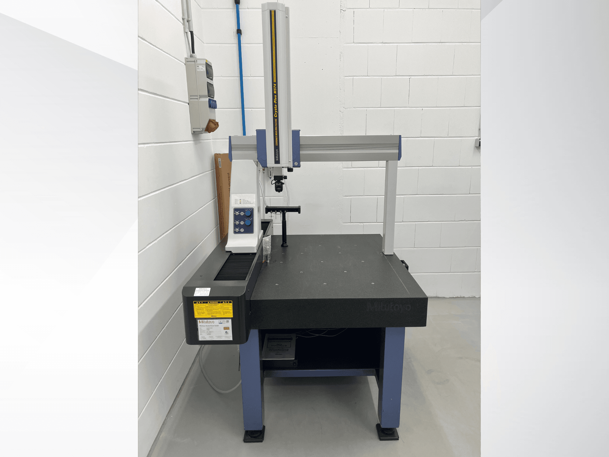 Máquina de medição por coordenadas Mitutoyo Crysta-Plus M574, vista frontal; apresenta uma ponte de medição horizontal e um painel de controlo.