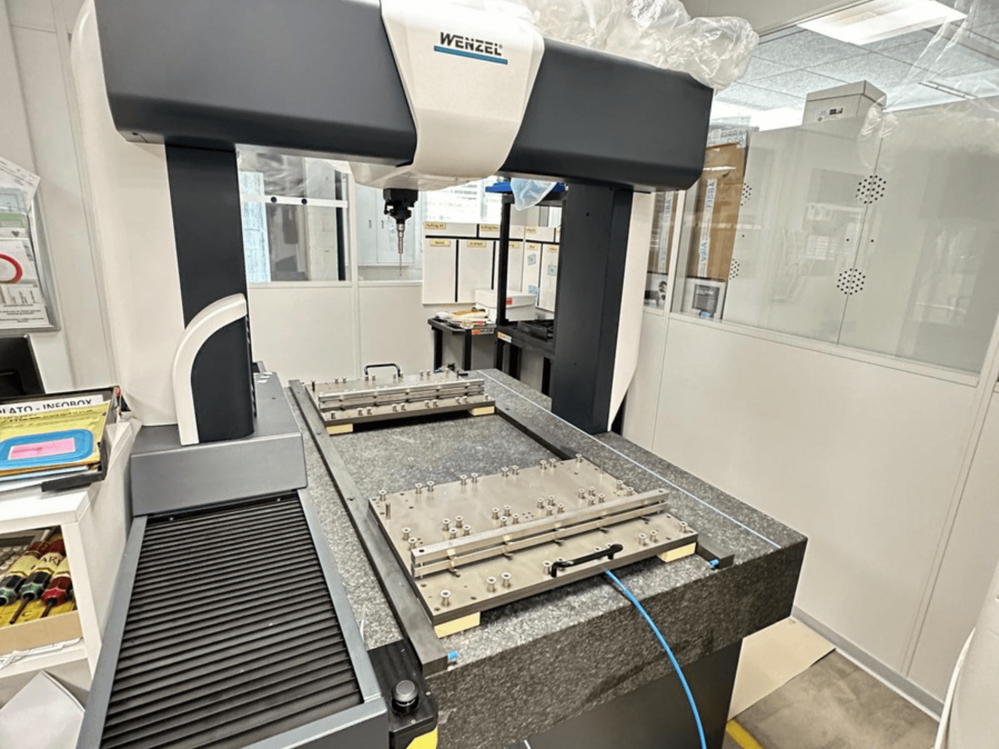 Máquina de medição por coordenadas (CMM) Wenzel LH 65 num ambiente de laboratório, apresentando uma base de granito com plataforma de medição ajustável e braço suspenso.