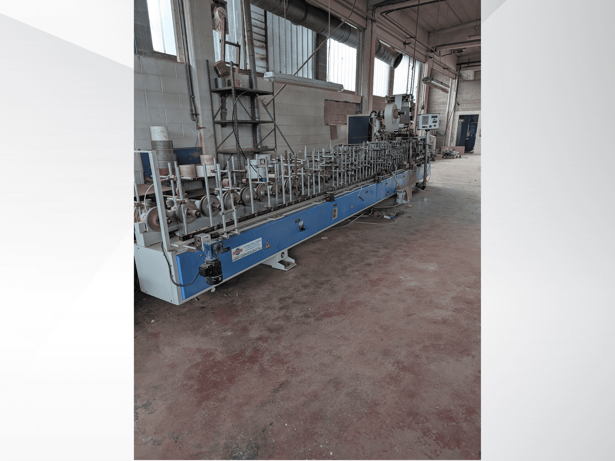 Vista frontal de uma máquina PUR-33-L para madeira, com vários fusos e um design azul elegante num ambiente industrial.