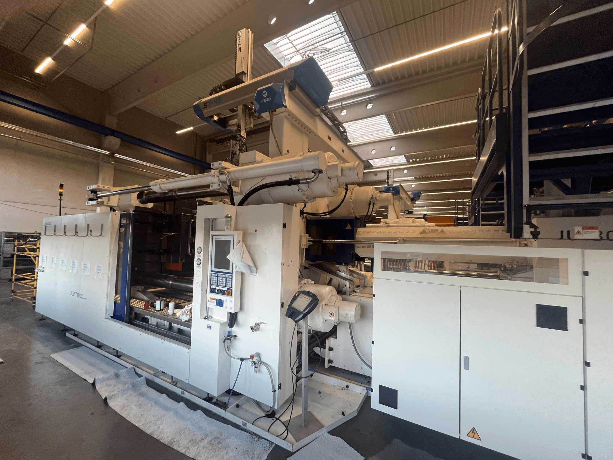 Vista frontal de uma máquina têxtil Autefa, com painel de controlo, componentes e ambiente industrial.