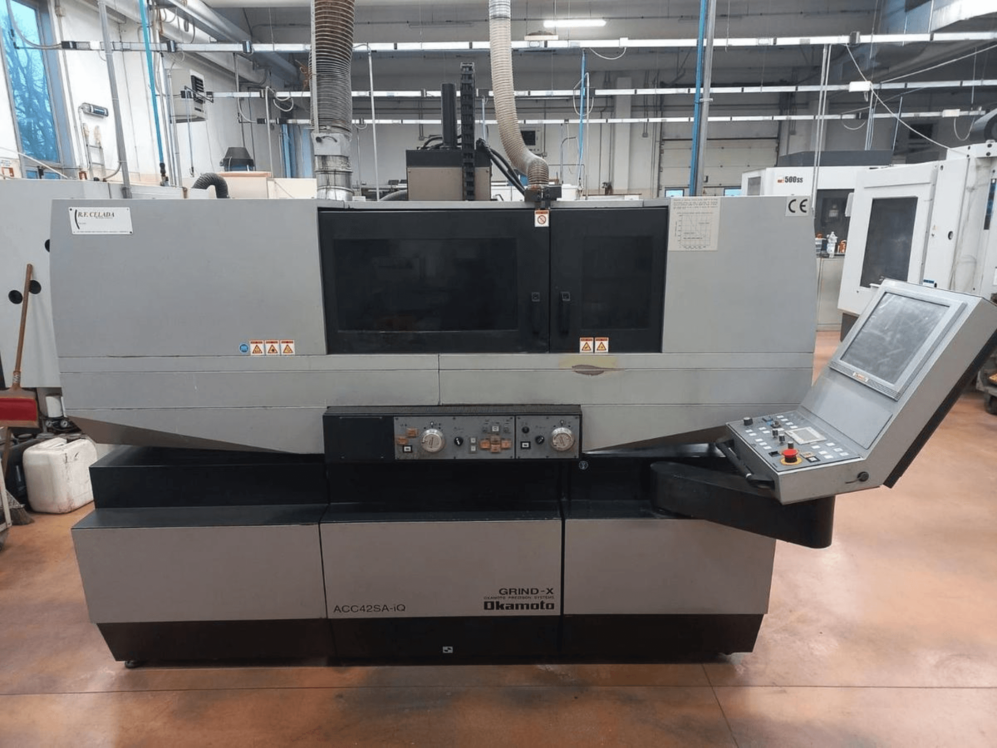Vista frontal da máquina de retificação de superfícies OKAMOTO ACC 42 SA-iQ, mostrando o painel de controlo e os indicadores de segurança.