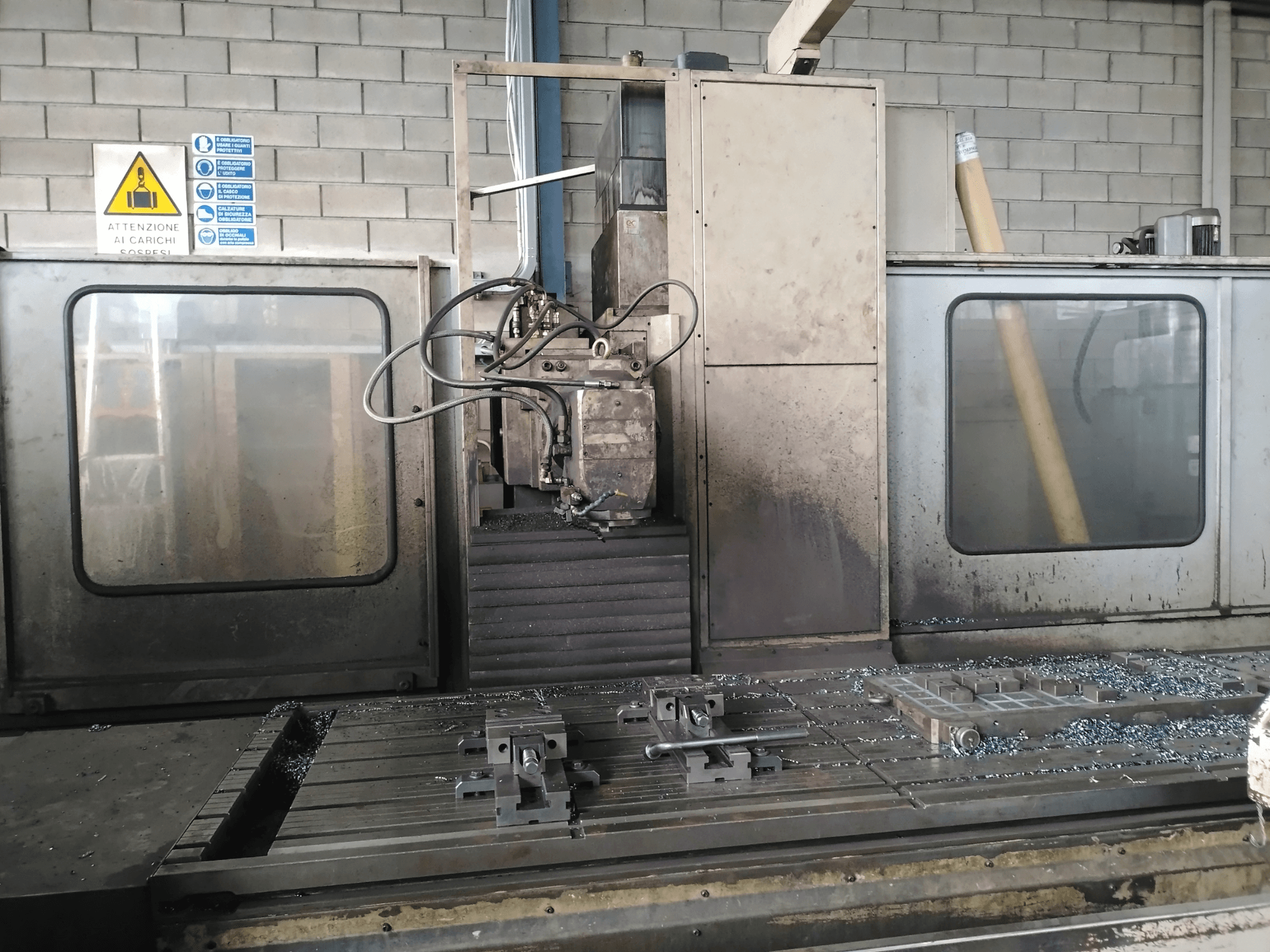 Fresadora TIGER TFA6 numa oficina, vista frontal mostrando ferramentas e aparas de metal na mesa.