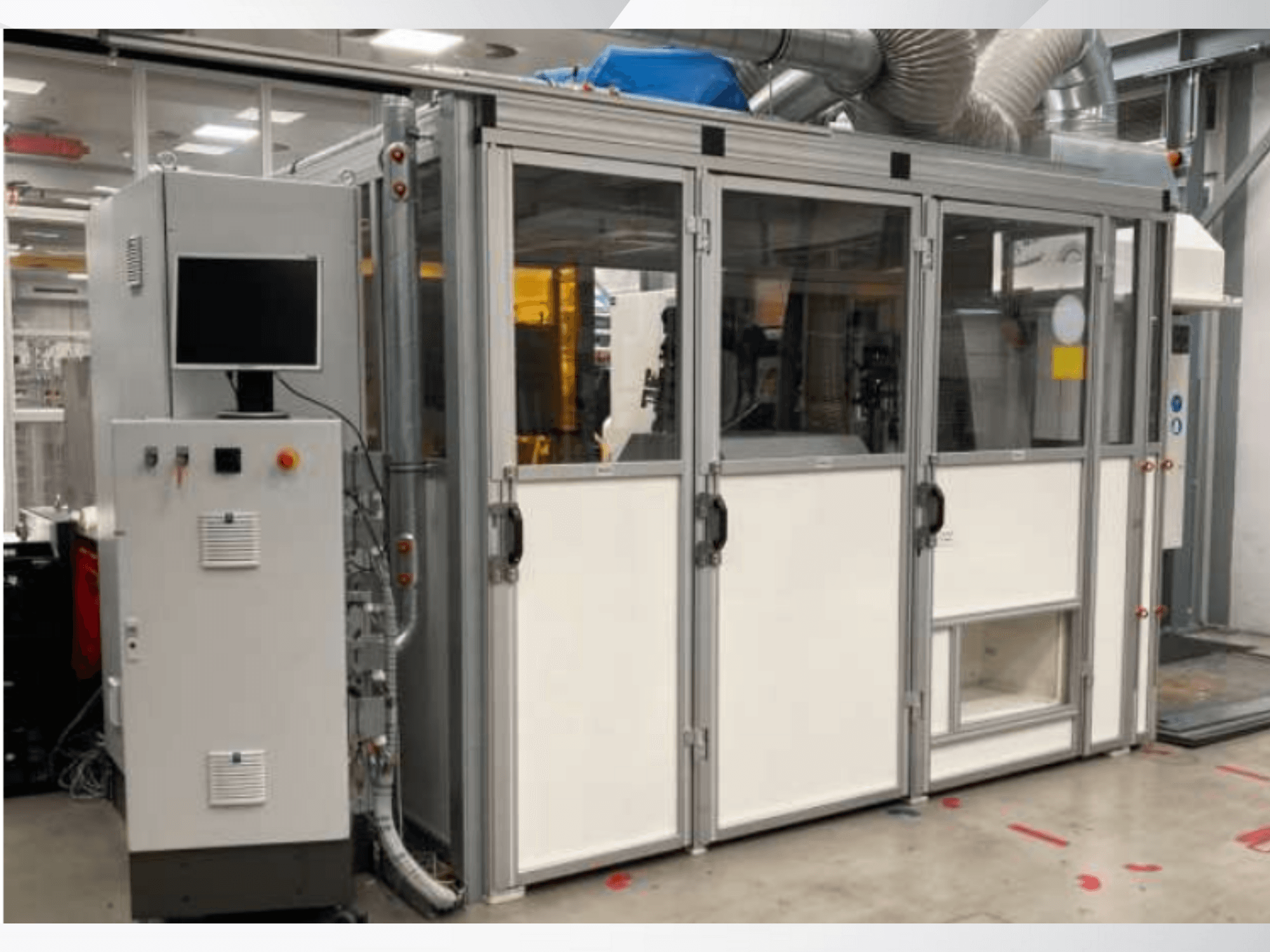 Máquina industrial com painel de controlo, vista frontal; apresenta portas de vidro, condutas de ventilação e cablagem visível.