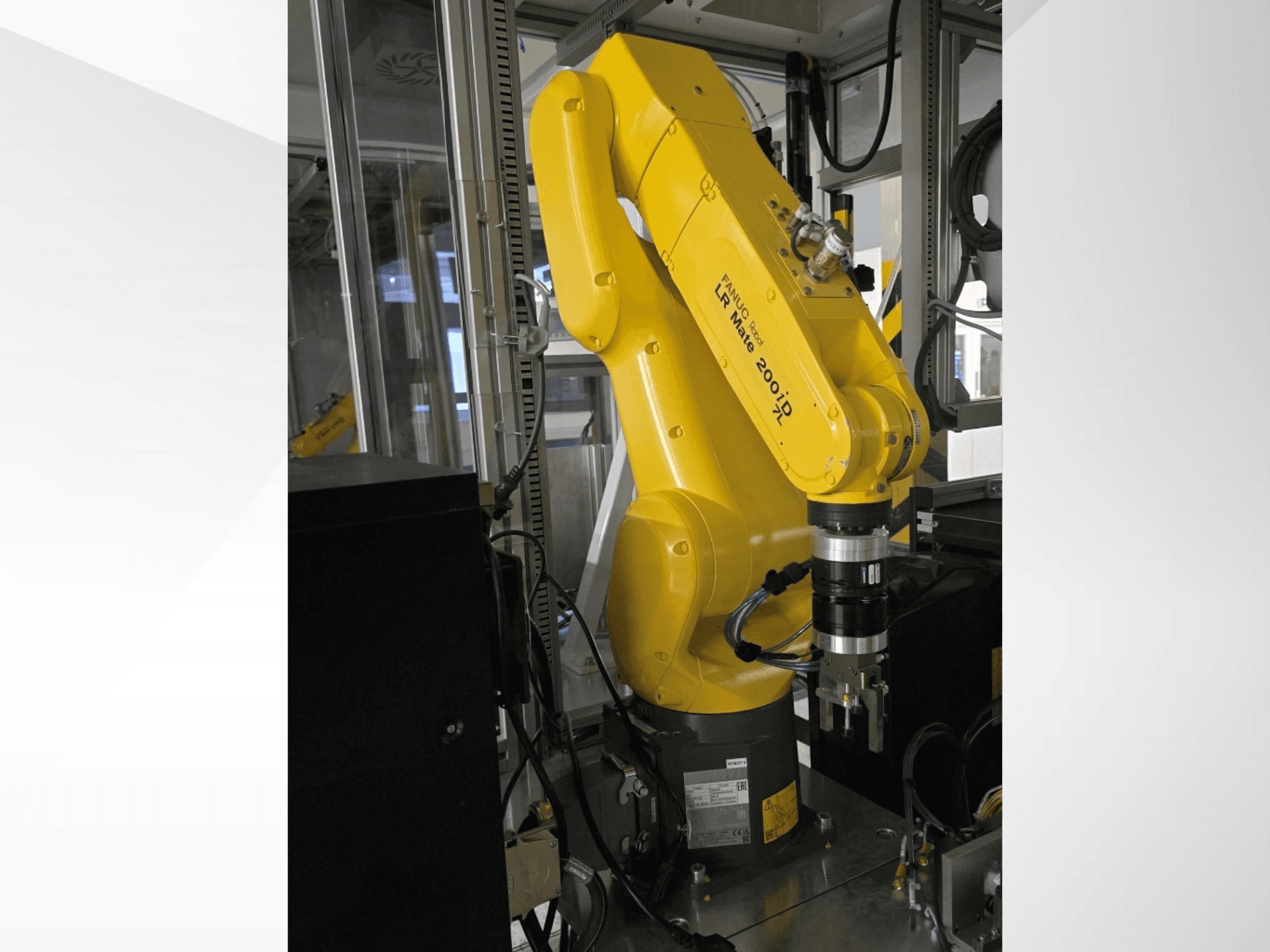 Braço robótico Fanuc LR Mate 200iD amarelo apresentado numa vista lateral, com uma pinça e vários cabos ligados.