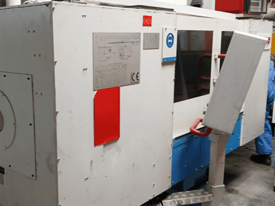 Máquina de retificação cilíndrica Kapp RNS 55, vista lateral que mostra o painel de controlo e os dispositivos de segurança.