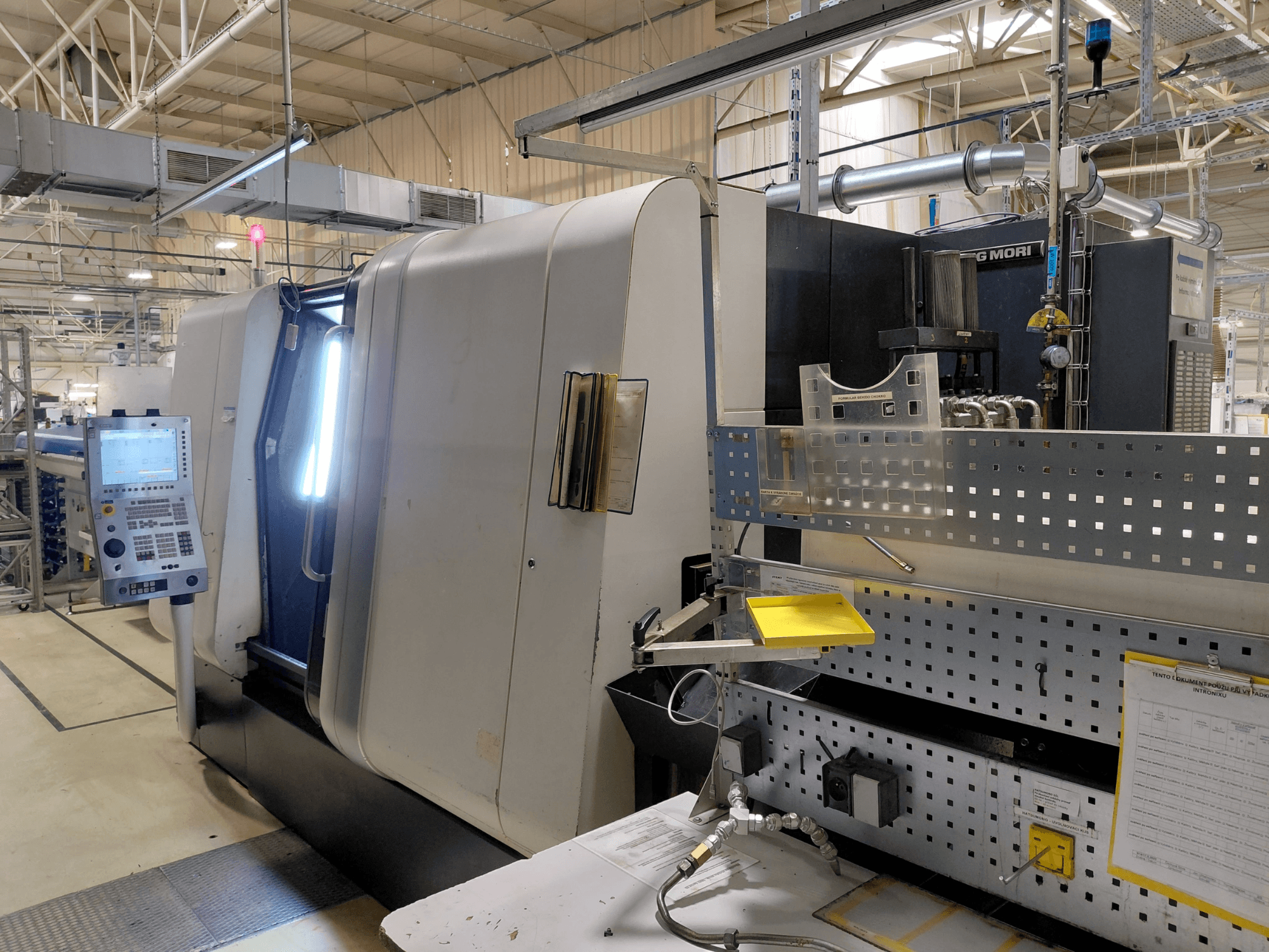 Máquina de tornear multifusos DMG MORI Sprint 65 linear, vista frontal, mostrando o painel de controlo e as caraterísticas da máquina.