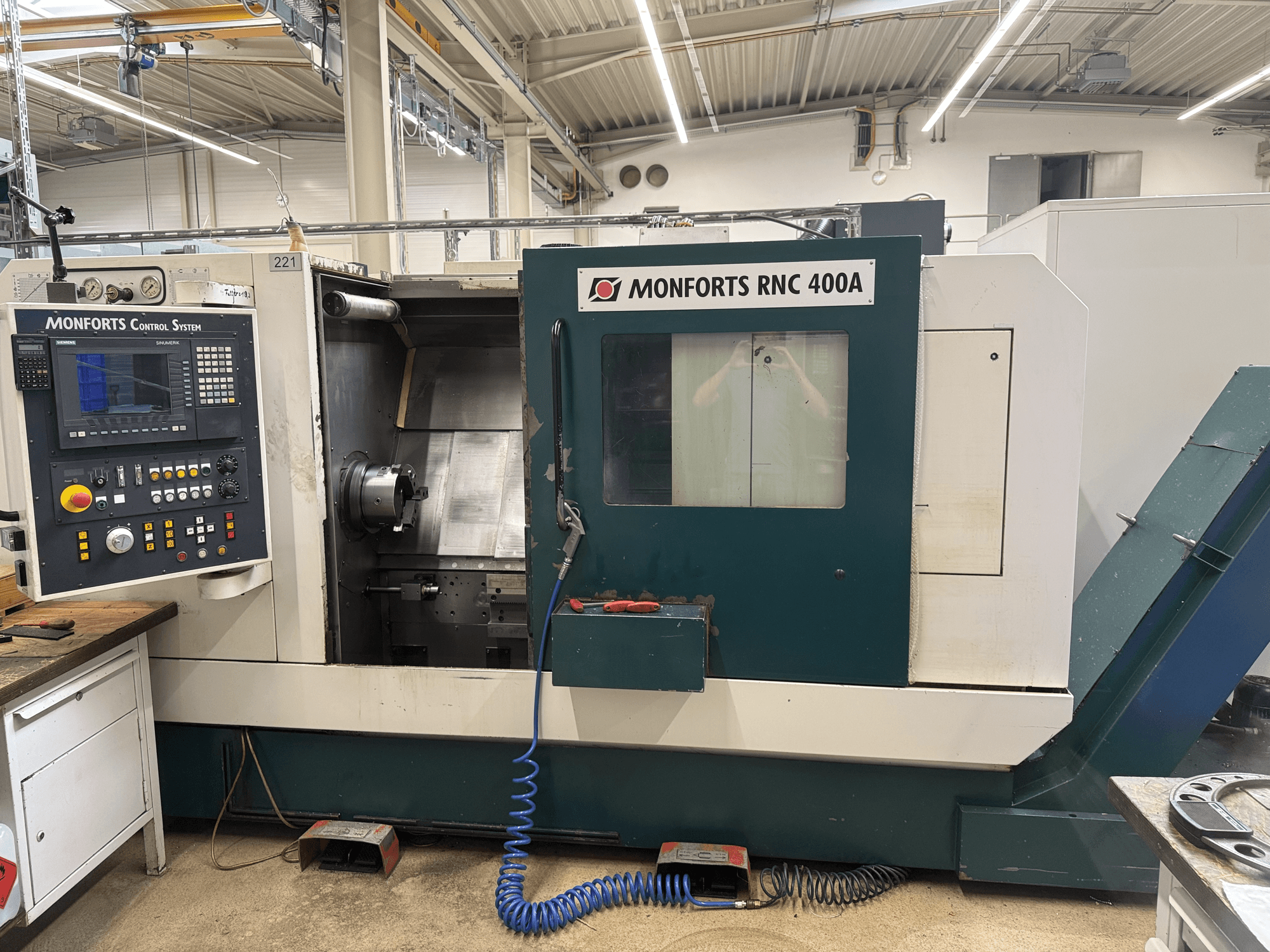 Torno horizontal Monforts RNC 400 A, vista frontal, mostrando o painel de controlo e o interior da máquina.