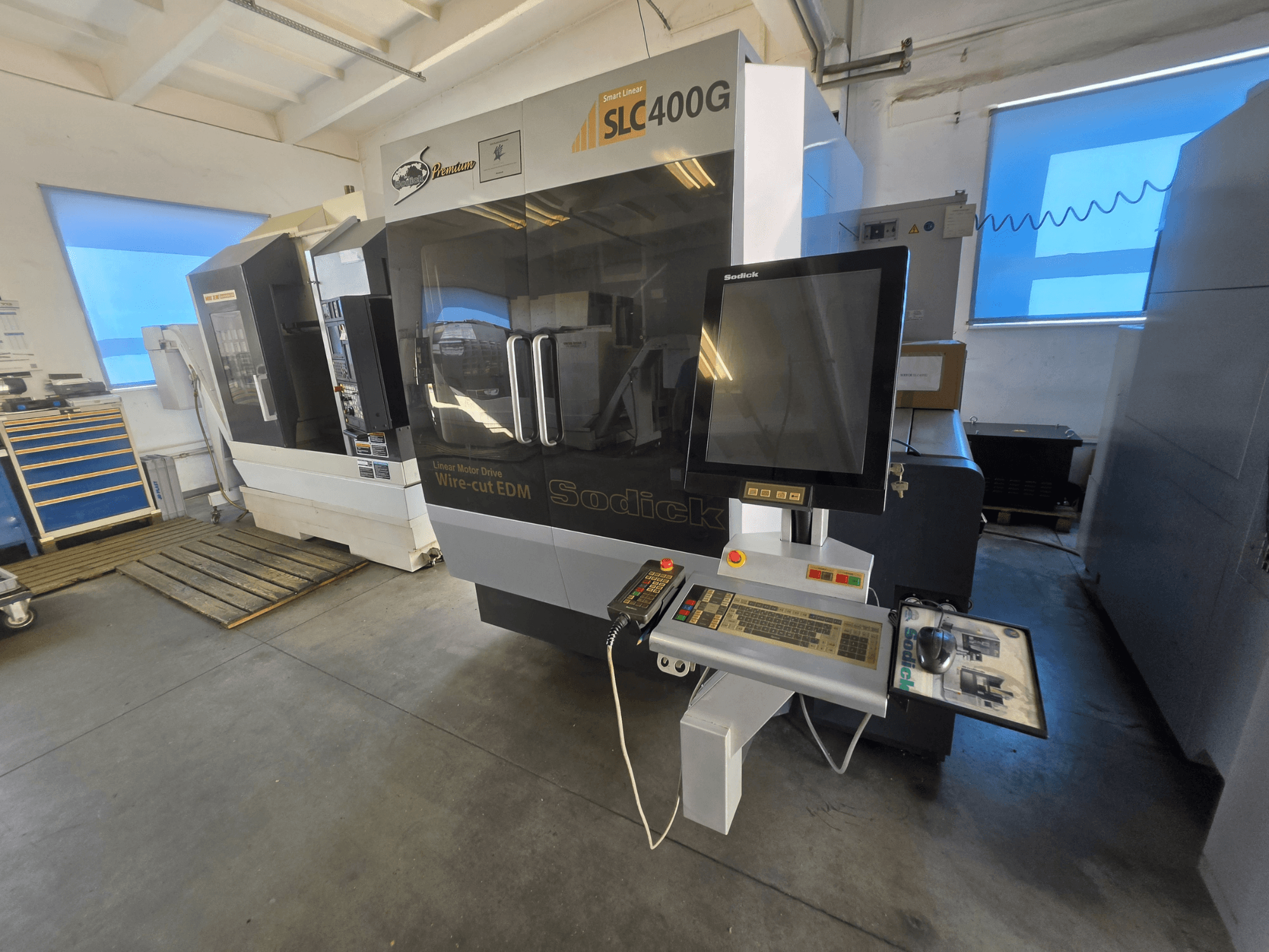 Máquina de eletroerosão por fio Sodick SLC400G, vista frontal com painel de controlo e ecrã tátil num ambiente de oficina.
