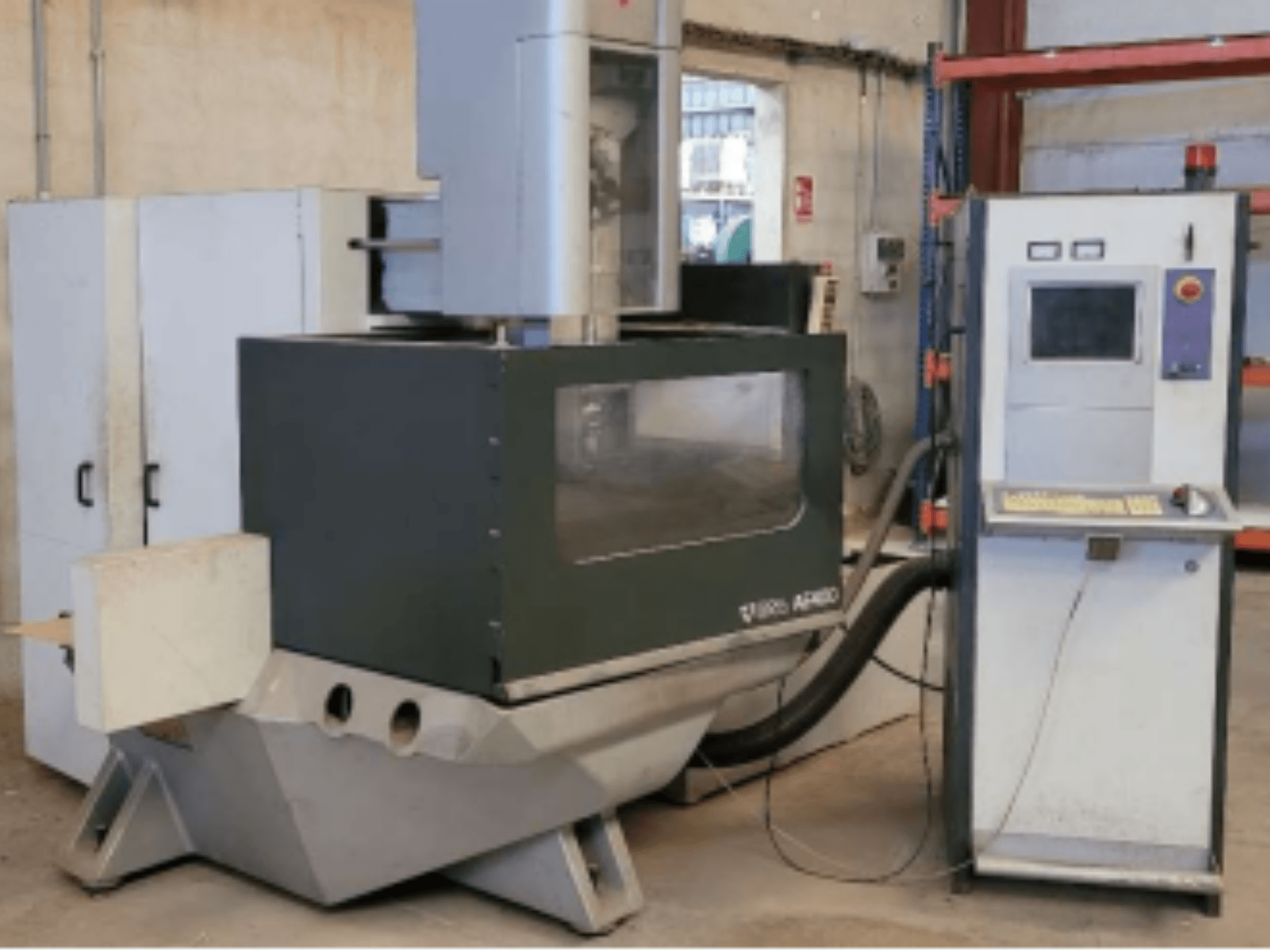 Máquina EDM de fio ONA AE 400 numa oficina, com um painel de controlo à direita e uma grande área de corte.