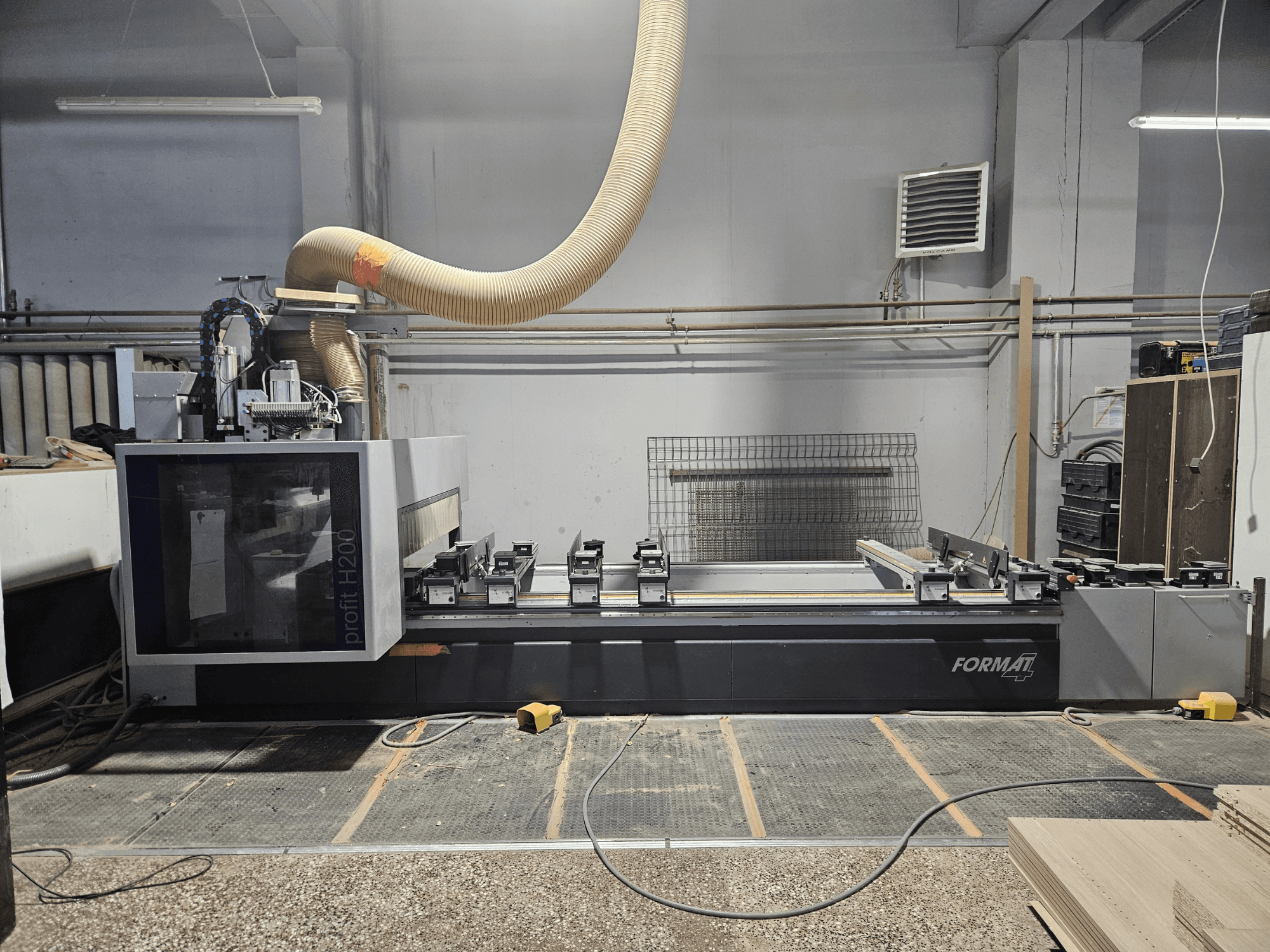 Uma máquina CNC FORMAT profit H200 numa oficina, vista lateral, mostrando a superfície de trabalho e o sistema de extração de poeiras.