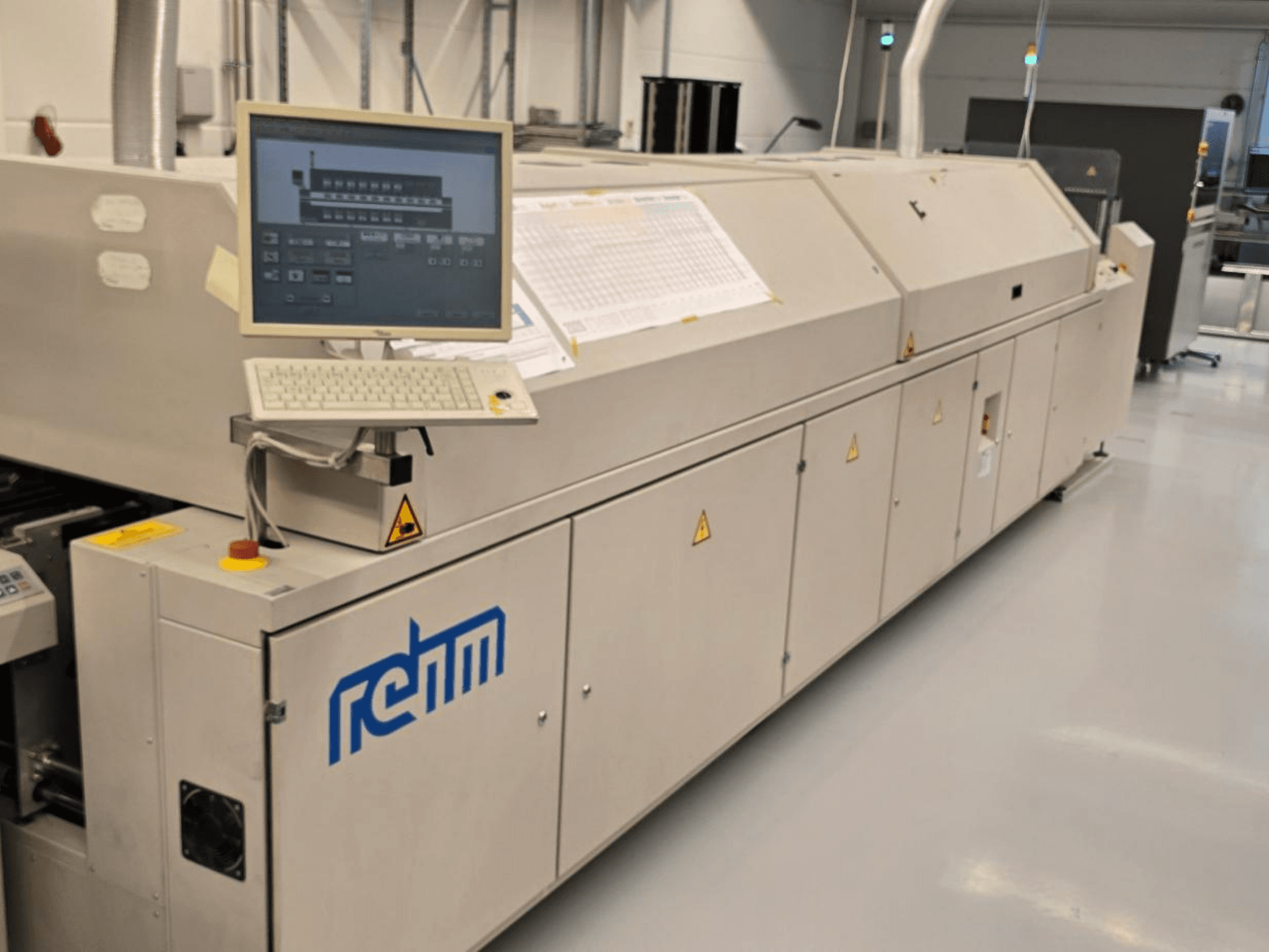 Equipamento de automação REHM VXS nitro 2450, vista frontal; inclui monitor, teclado e painel de controlo para as operações.