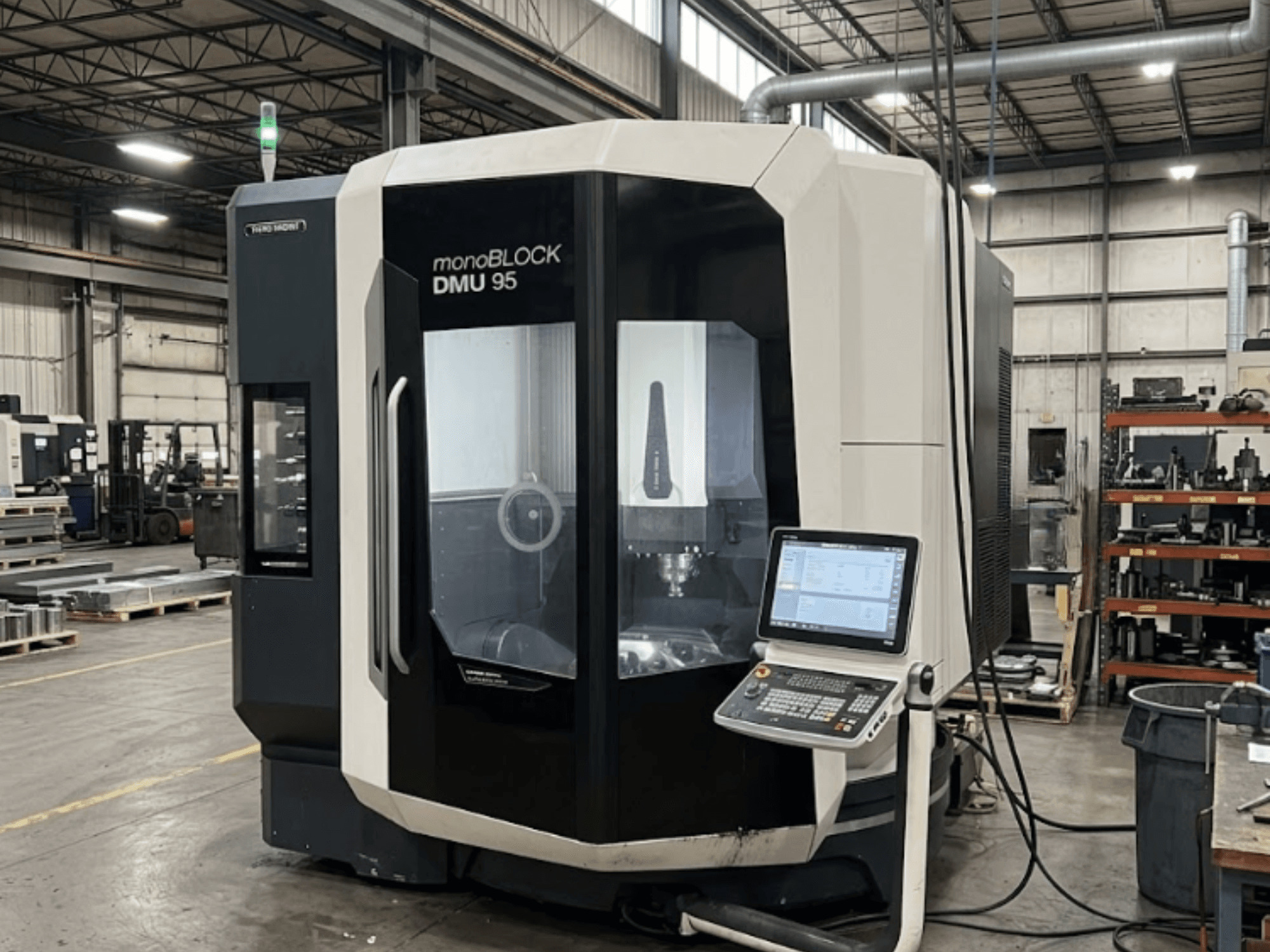 Centro de maquinagem vertical DMG MORI DMU 95 Monoblock numa fábrica, com o painel de controlo visível, vista frontal.