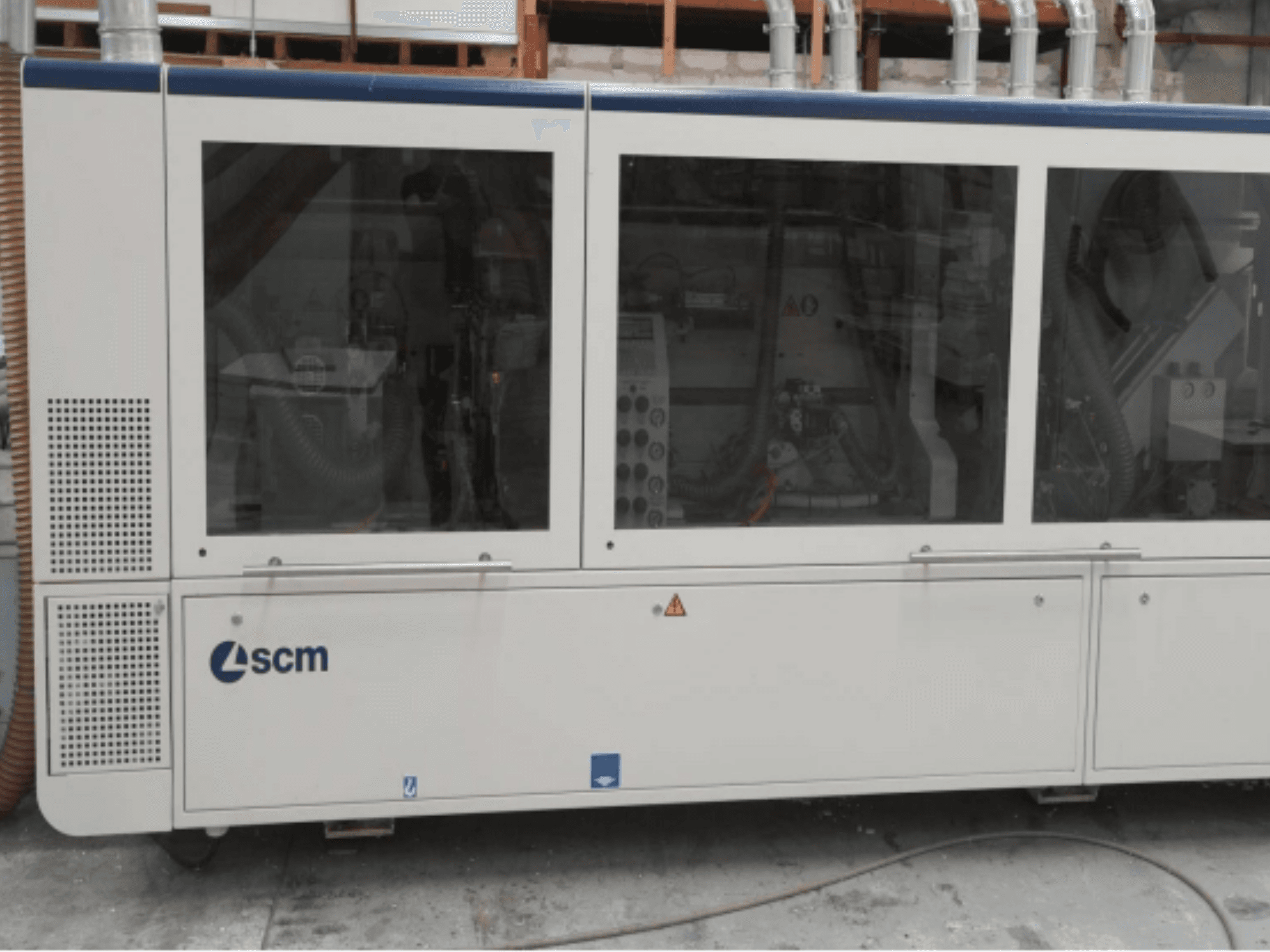 Máquina industrial SCM, vista lateral, com painéis transparentes e aberturas de ventilação visíveis; concebida para a eficiência dos processos de fabrico.