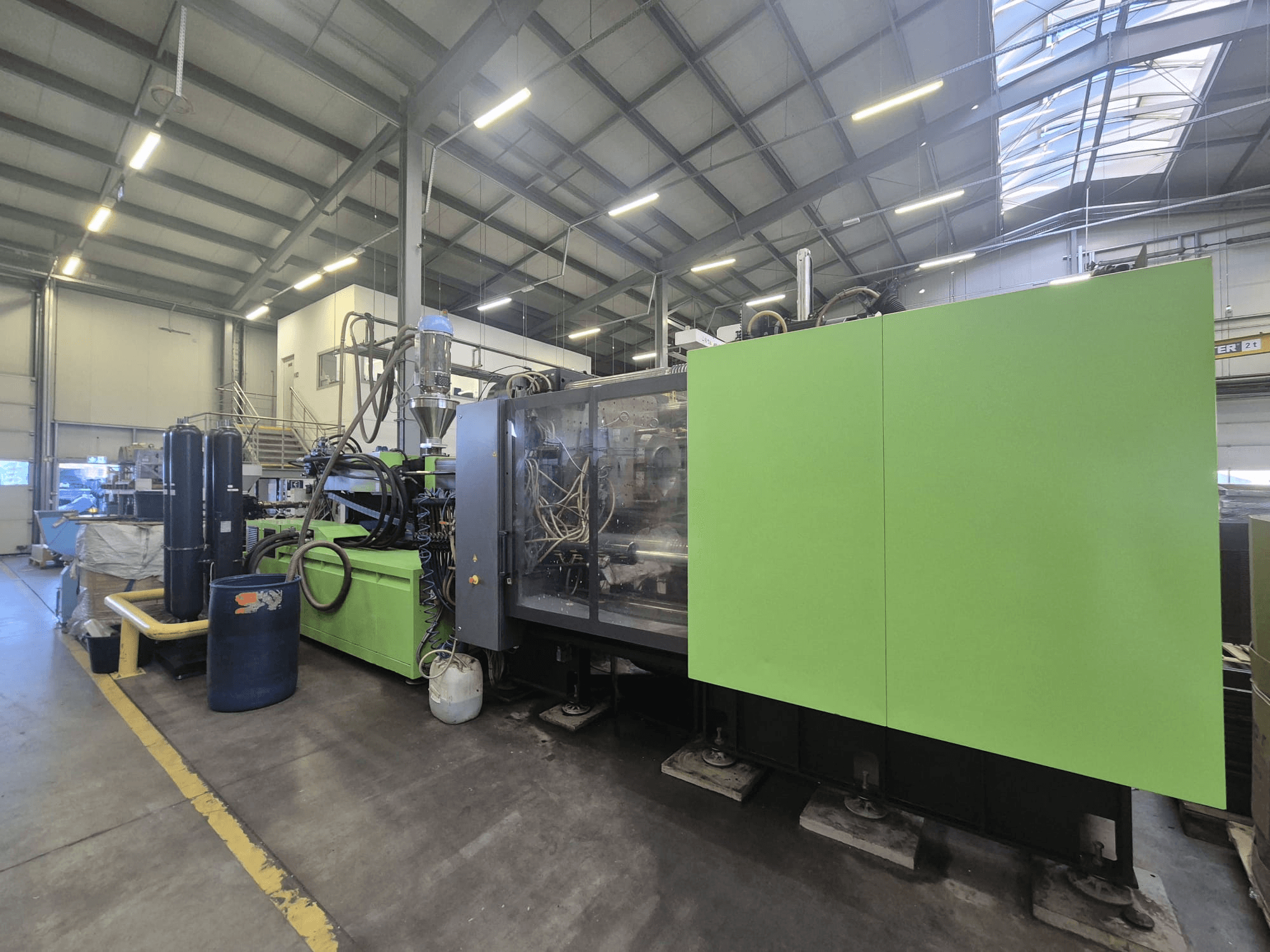 Máquina de moldagem por injeção hidráulica Engel duo 5160/700 num ambiente fabril, vista de lado, mostrando o seu exterior verde e os seus componentes.