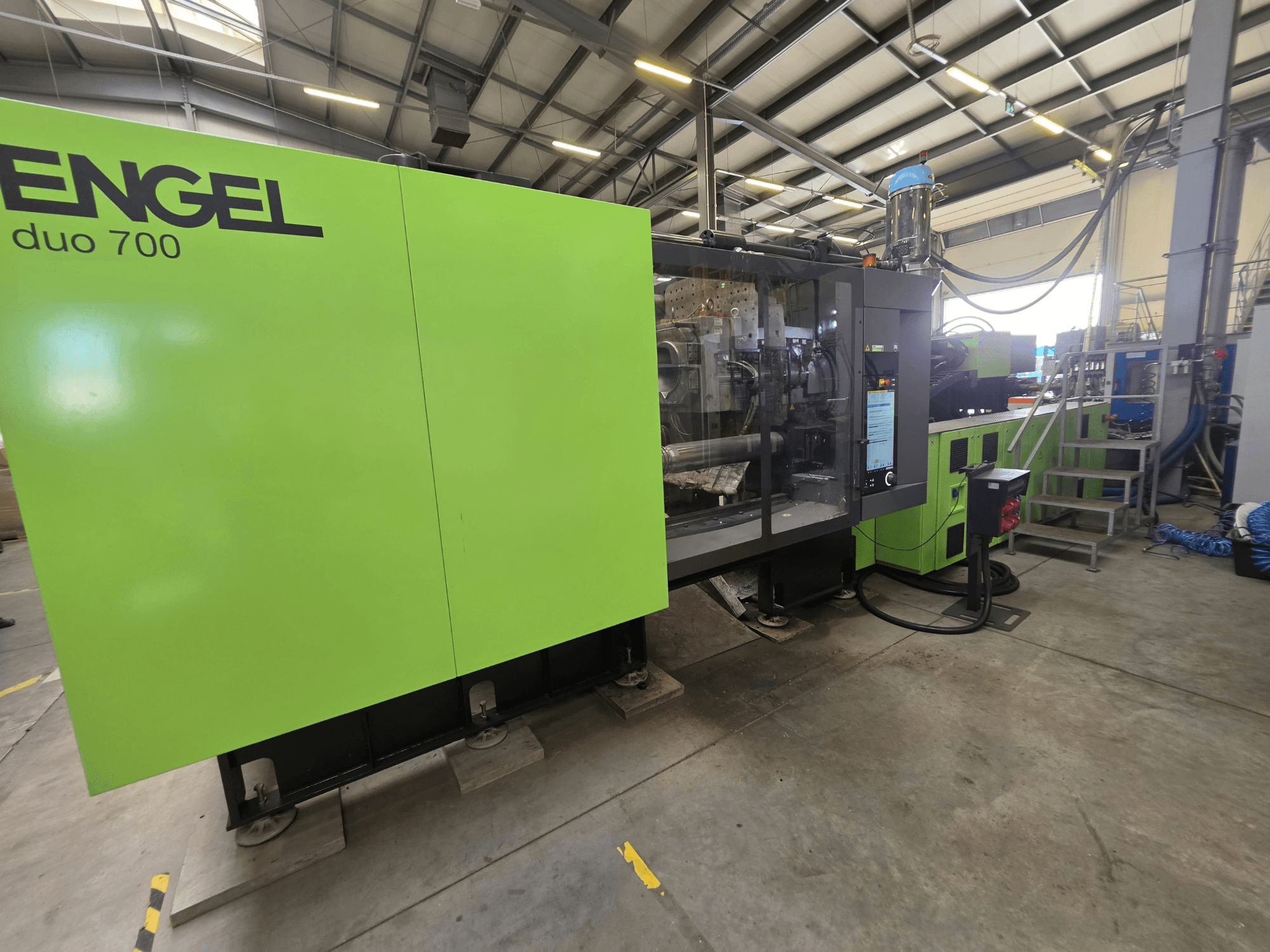 Máquina de moldagem por injeção hidráulica Engel Duo 700, vista frontal, mostrando o exterior verde e o painel de controlo.