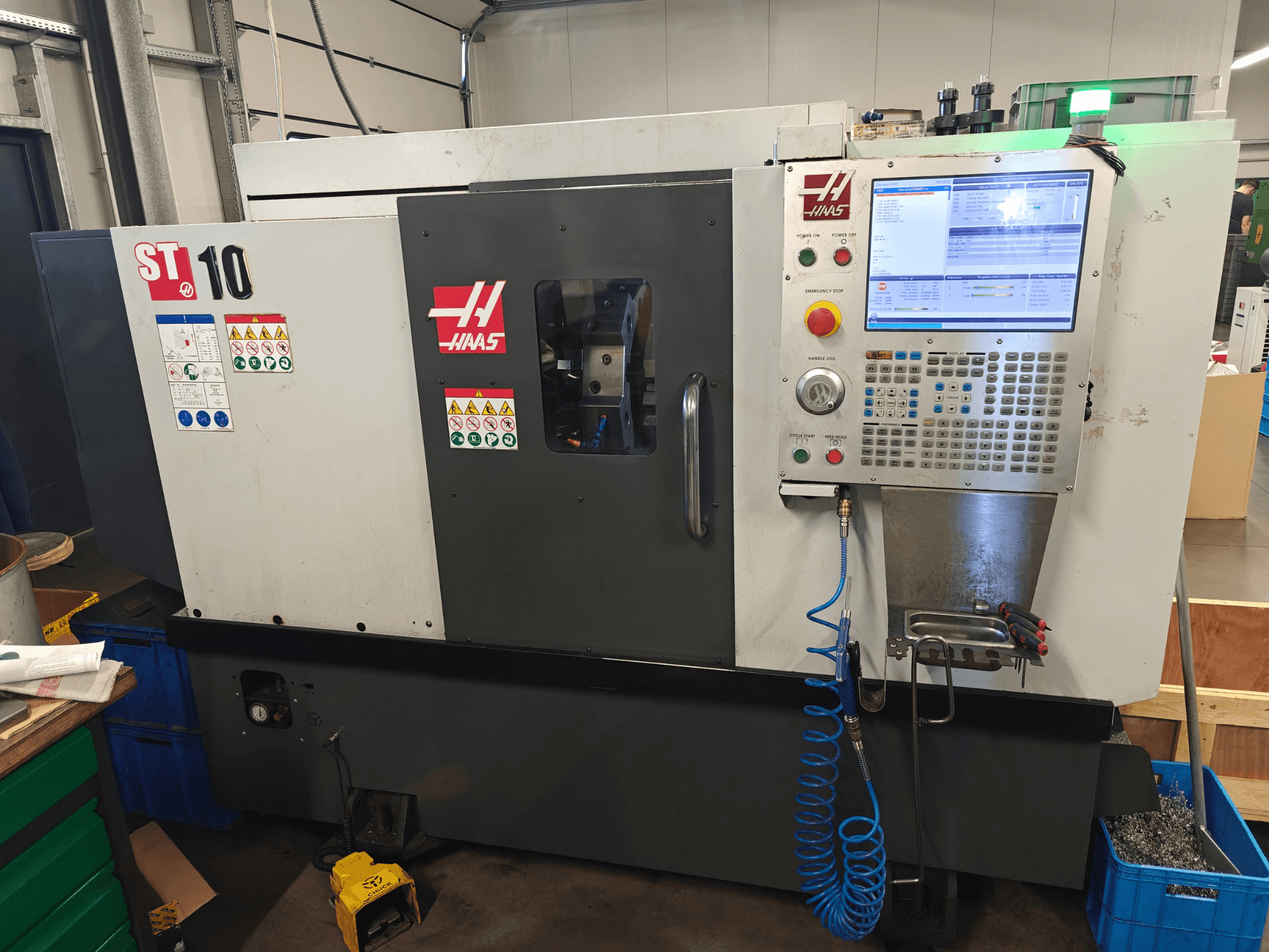 Torno horizontal Haas ST-10, vista frontal, mostrando o painel de controlo, as etiquetas de segurança e a estrutura da máquina.