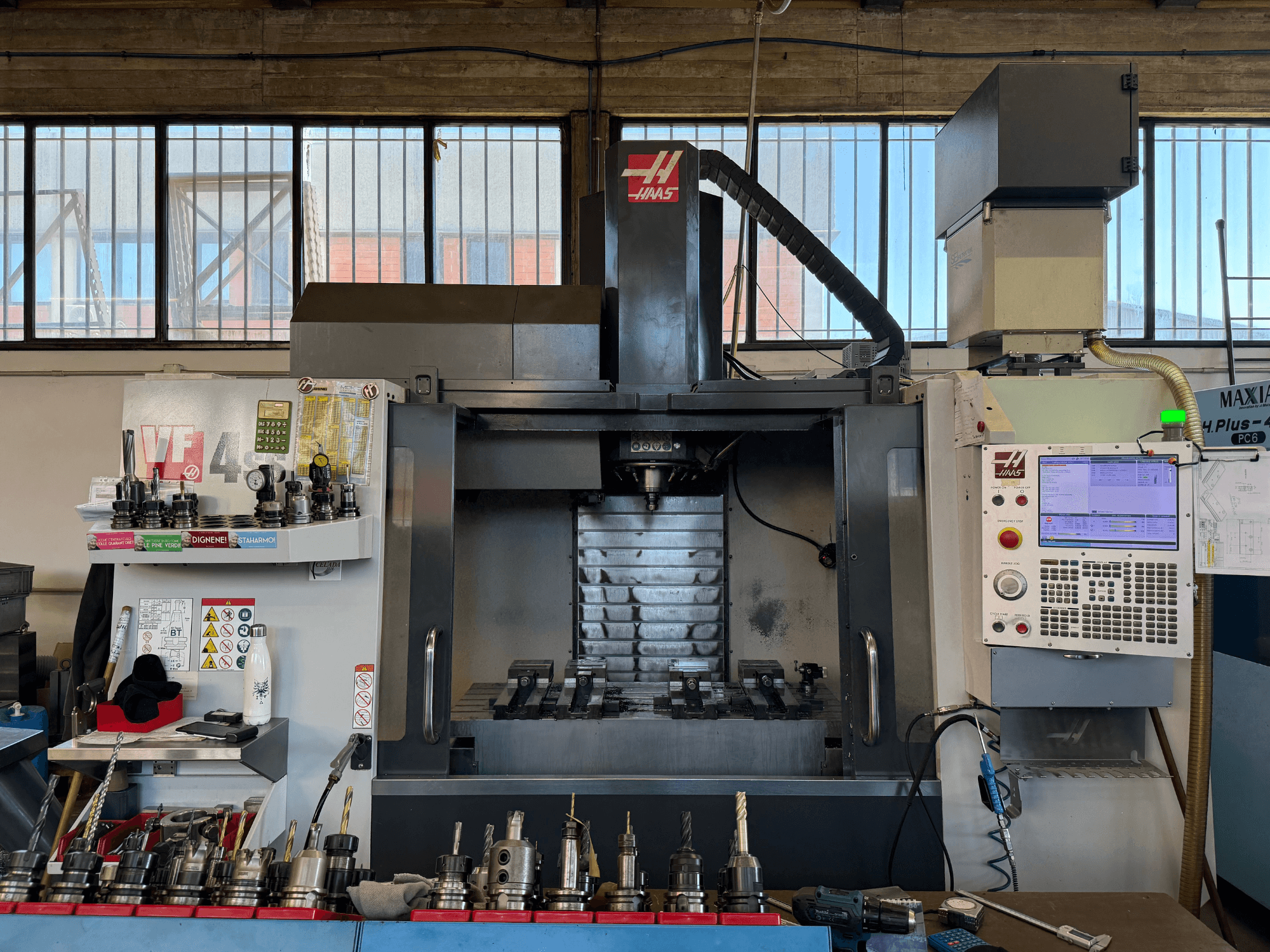 Centro de maquinagem vertical HAAS VF-4SS, vista frontal, com o painel de controlo, os porta-ferramentas e a área do fuso visível.