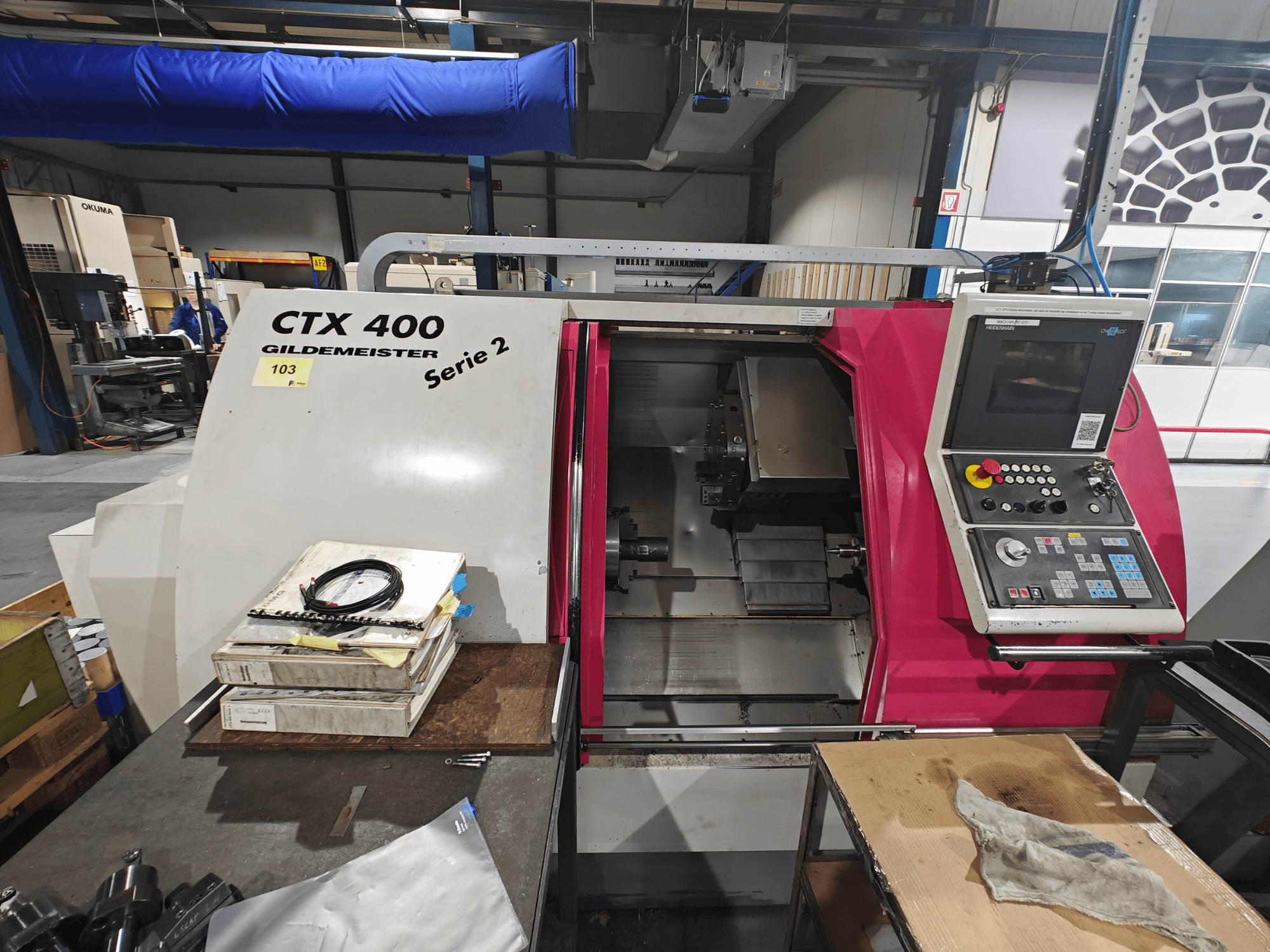 Torno Gildemeister CTX 400 mostrado de frente, com um painel de controlo com botões, visor e espaço de trabalho.