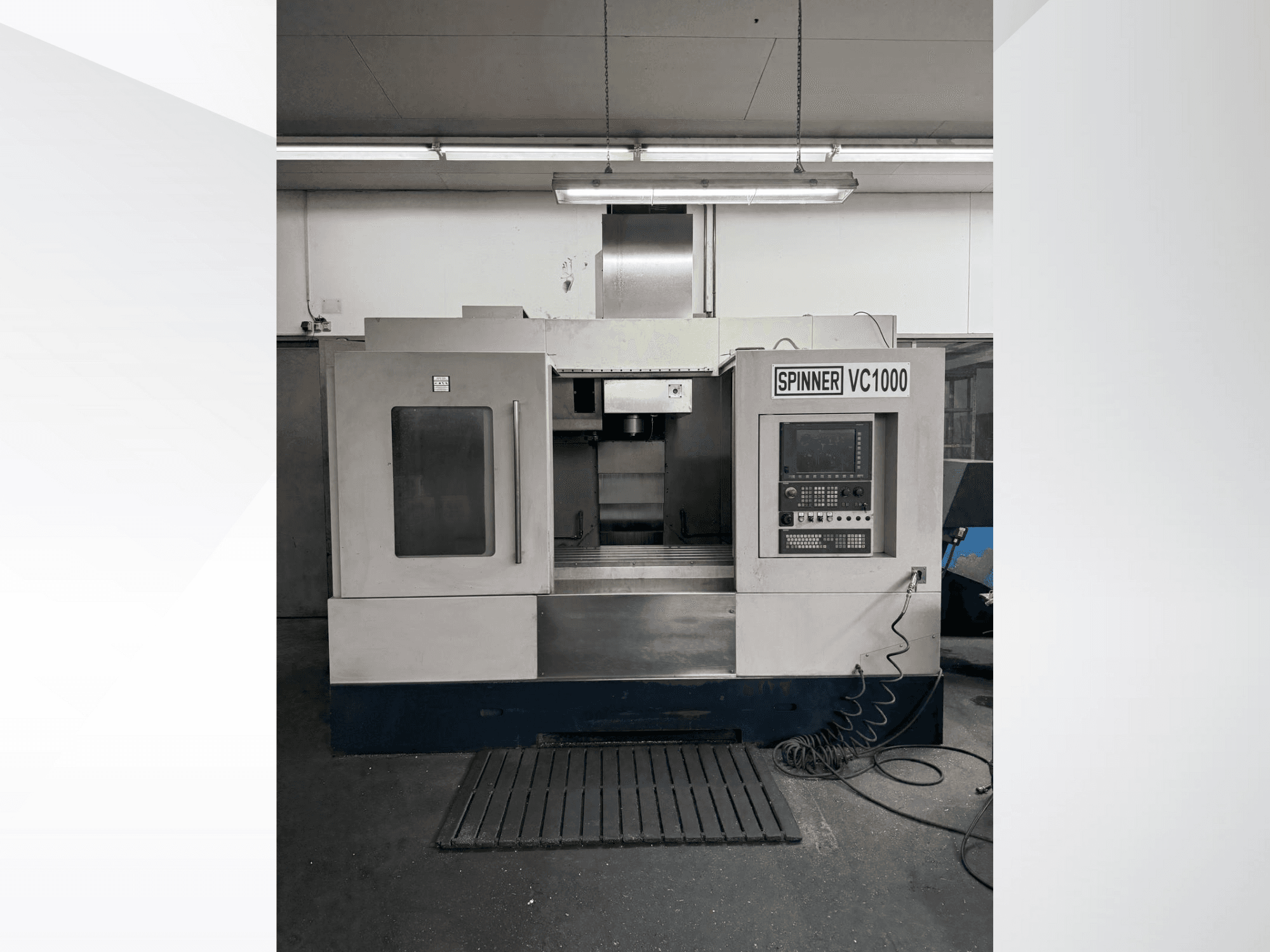 Centro de maquinação Spinner VC1000 em vista frontal, com um painel de controlo e uma grande área de trabalho com um acabamento cinzento.