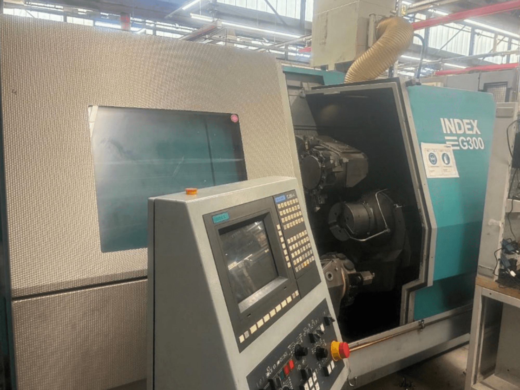 Índice: Torno horizontal G300, vista frontal, mostrando o painel de controlo e o acesso livre ao interior da máquina.