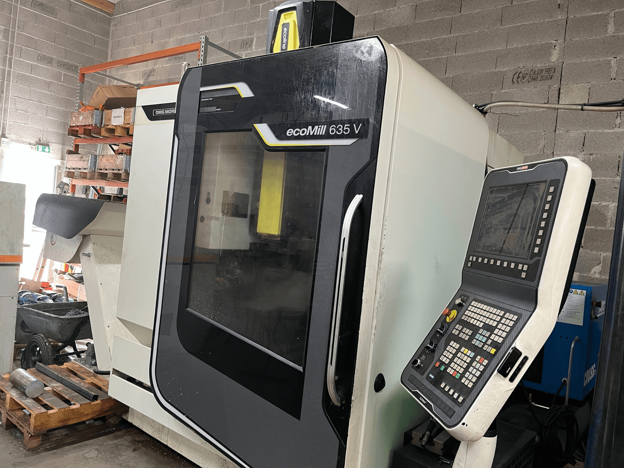 Fresadora CNC EcoMill 635 V, vista frontal, com painel de controlo com botões, localizada num espaço de trabalho industrial.