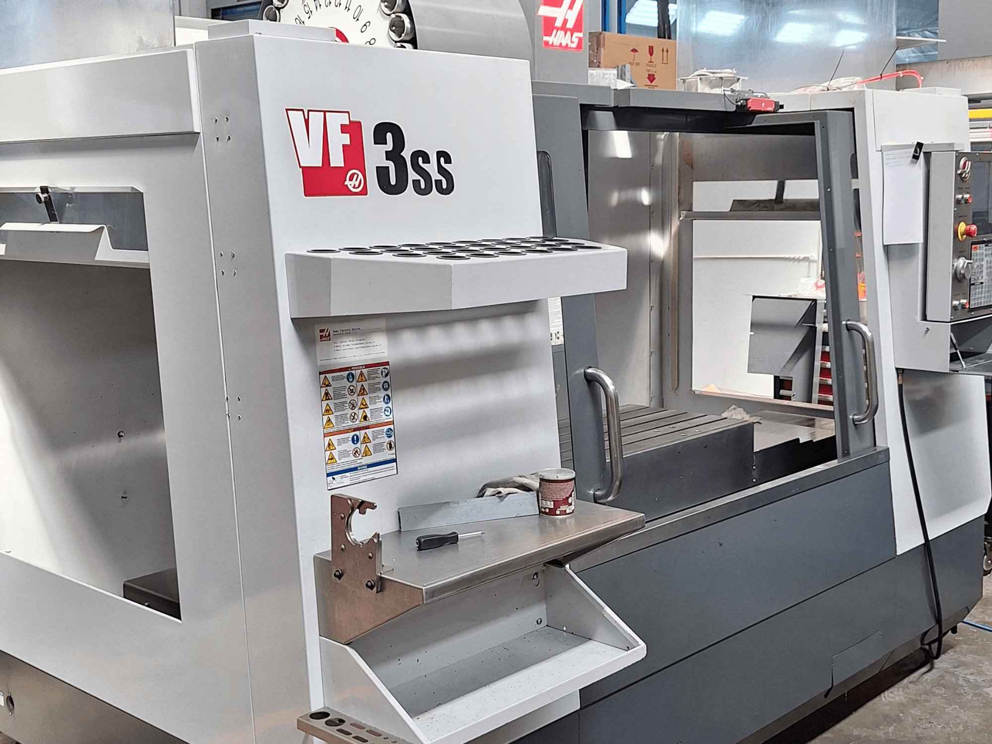 Centro de maquinação vertical Haas VF-3SS, vista frontal, mostrando o painel de controlo, o suporte de ferramentas e a área de trabalho.