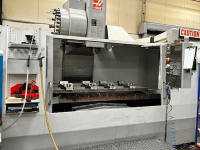 Centro de maquinação vertical HAAS VF-9/40HE, vista frontal, com suporte de ferramentas e acessórios visíveis na lateral.