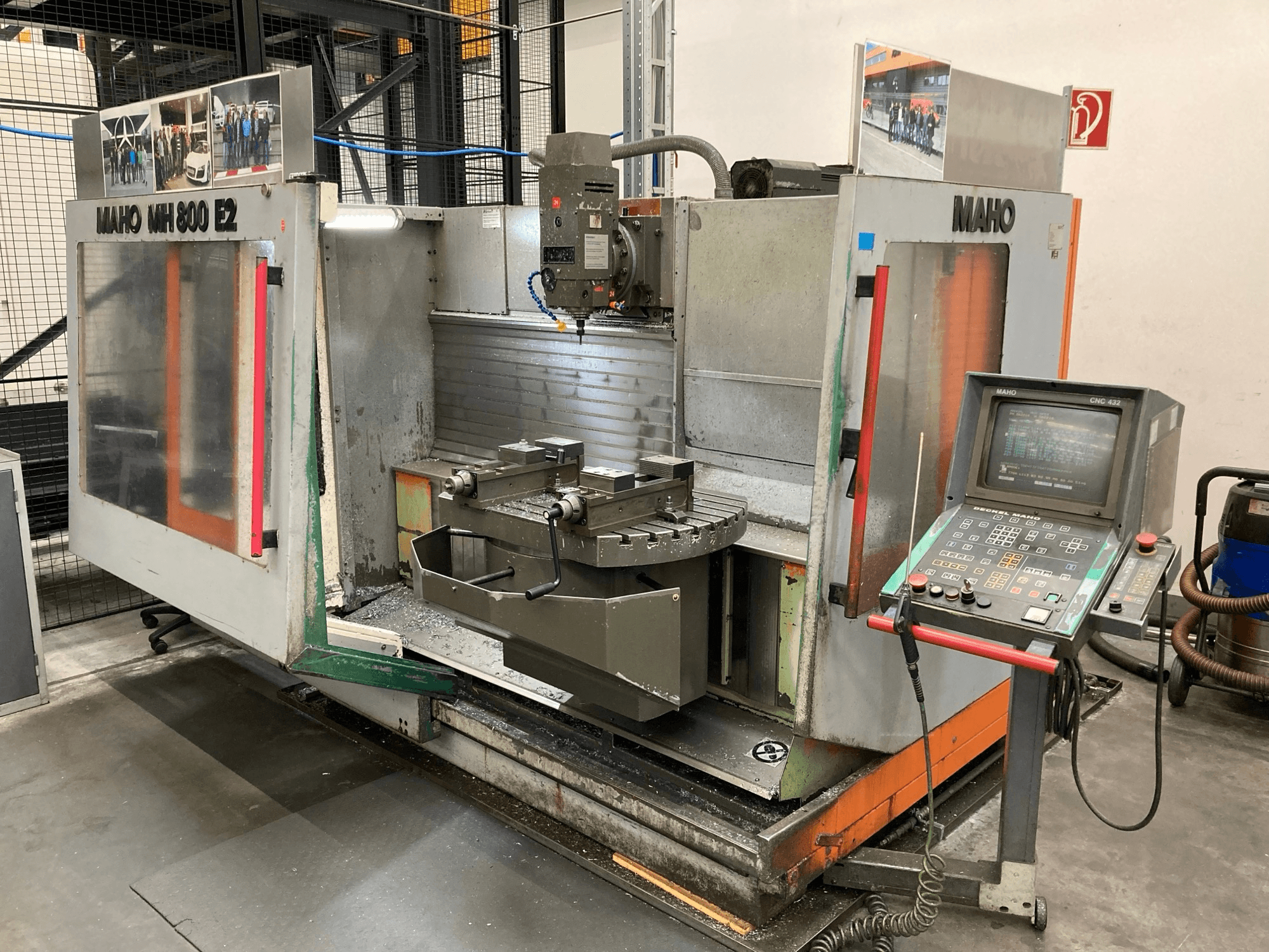 Fresadora CNC Maho MH 800 E2 em vista frontal com painel de controlo, fuso e mesa de trabalho visíveis.
