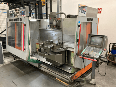 Fresadora CNC Maho MH 800 E2 em vista frontal com painel de controlo, fuso e mesa de trabalho visíveis.