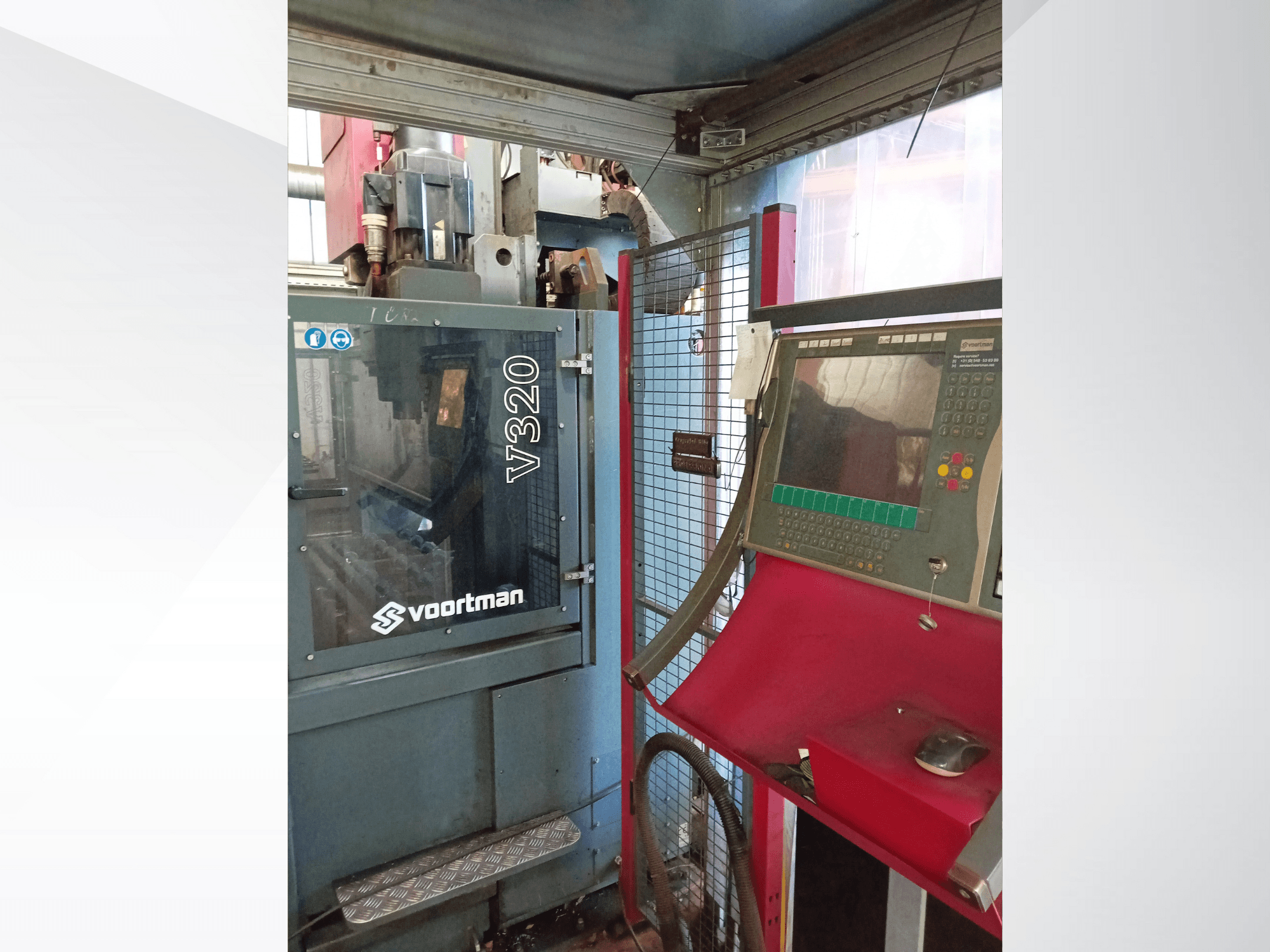Vista frontal da máquina CNC V320 da Voortman, com painel de controlo com botões, ecrã de visualização e caixa de rede de segurança.