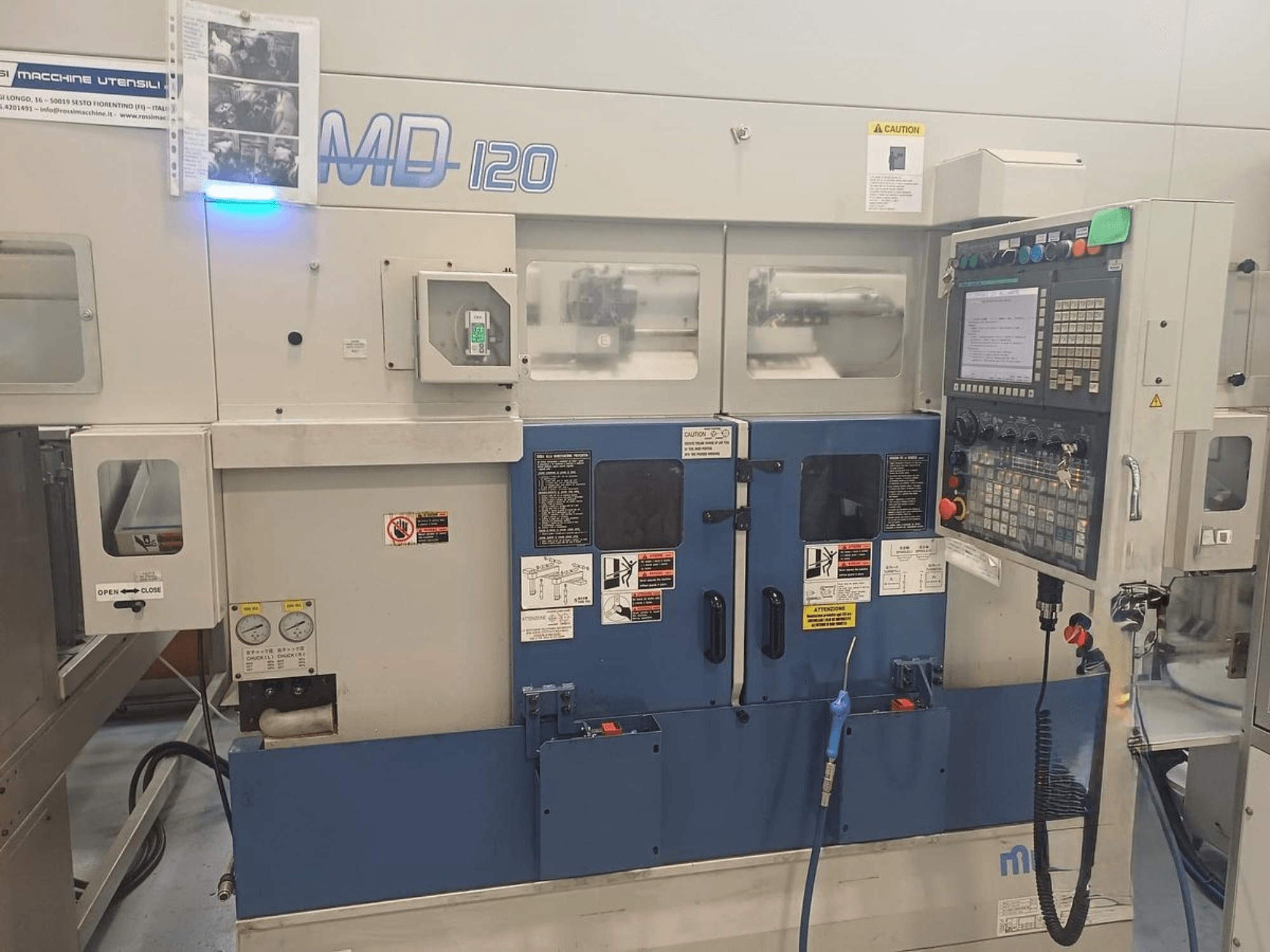 Máquina de torneamento horizontal MURATEC MD 120, vista frontal mostrando o painel de controlo, a porta e os manómetros.