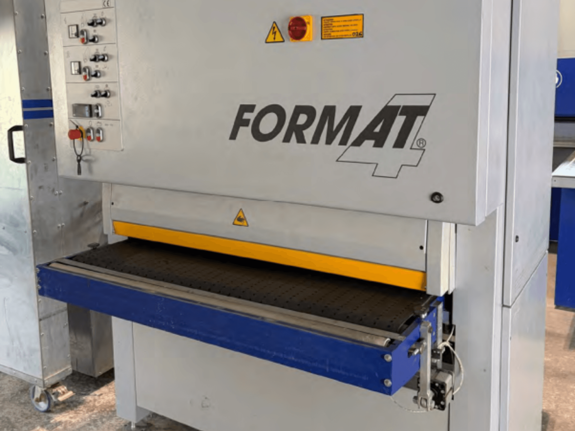 Lixadeira de cinta FORMAT4 Finish 1302, vista de frente, com painel de controlo, cinta de lixagem amarela e mesa transportadora azul.