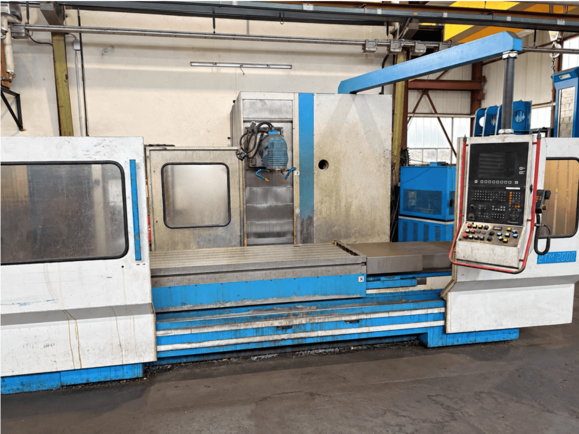 Máquina de retificação plana MIKRON BTM 2000 vista de frente, mostrando o painel de controlo e a mesa de retificação.
