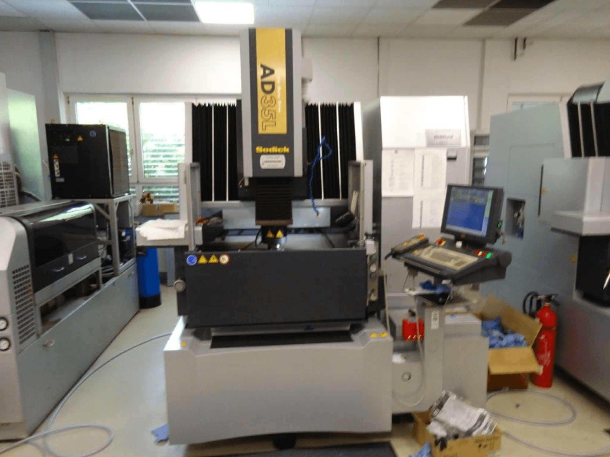 Máquina CNC Sodick AD35L vista de frente, com painel de controlo, unidade de refrigeração e indicadores de segurança.