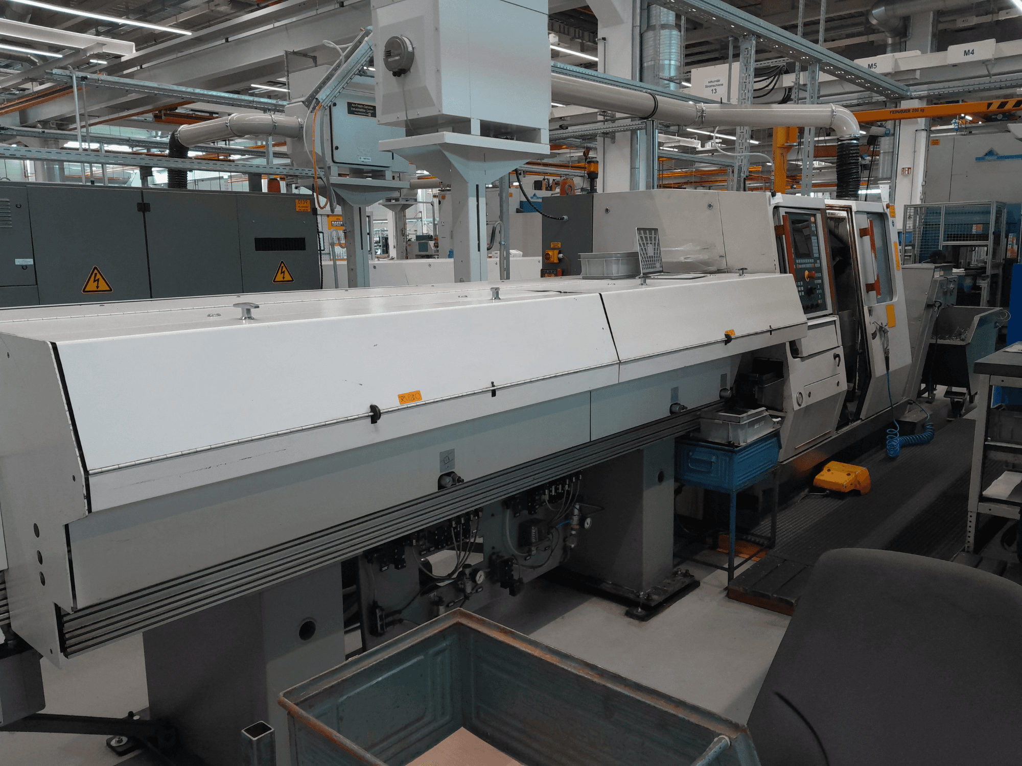 Torneiro horizontal TRAUB TNA 300, vista frontal; apresenta um design elegante, painel de controlo e espaço de trabalho operacional.