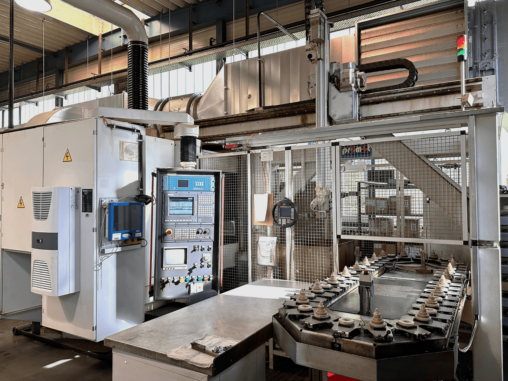 Máquinas industriais com painel de controlo, unidade de refrigeração e transportador. Vista frontal, com luzes brilhantes e sinalização de segurança.