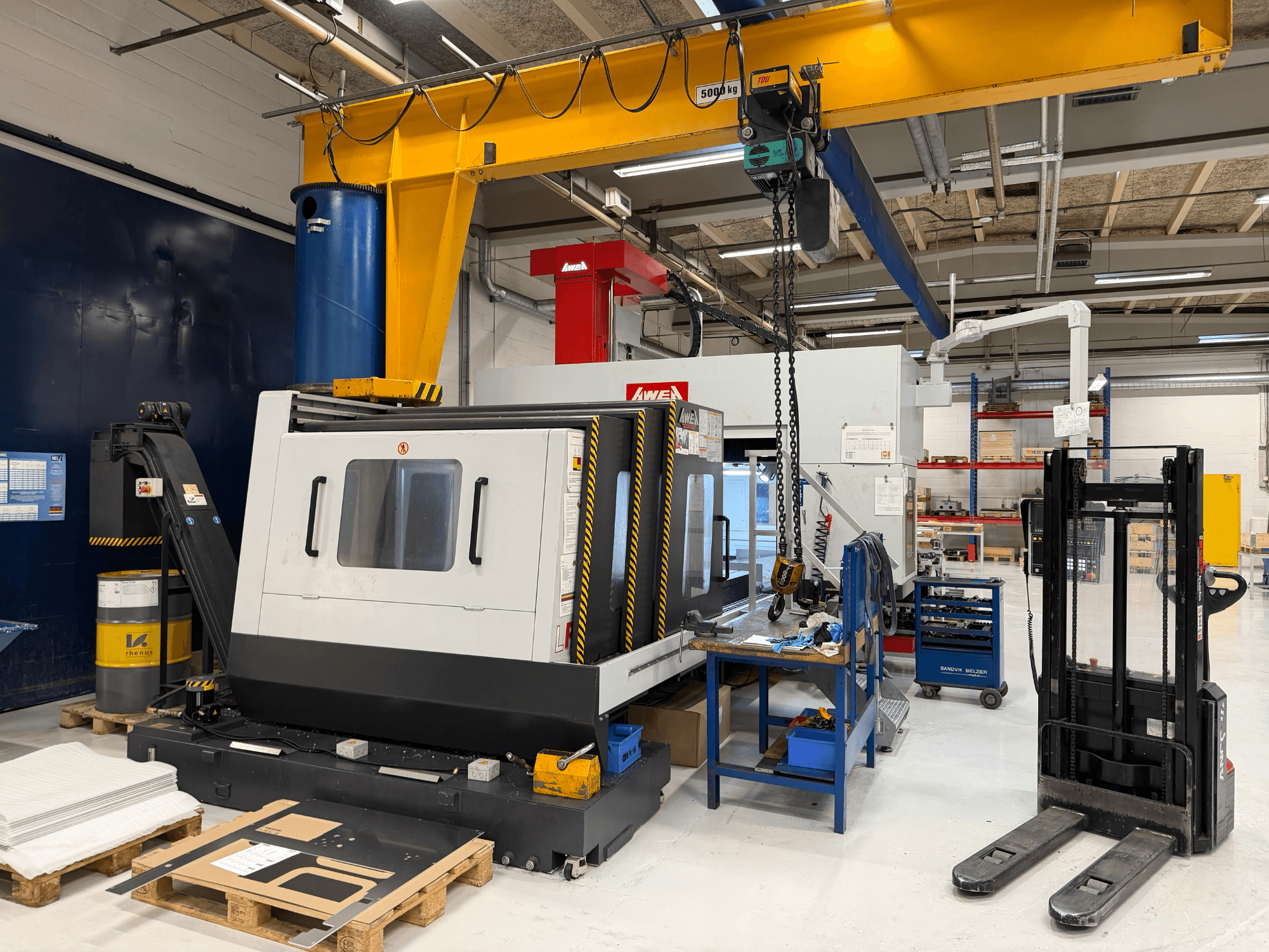 Fresadora de pórtico AWEA LP3016YF, vista frontal, com ferramentas, tanque azul e espaço de trabalho em fundo.