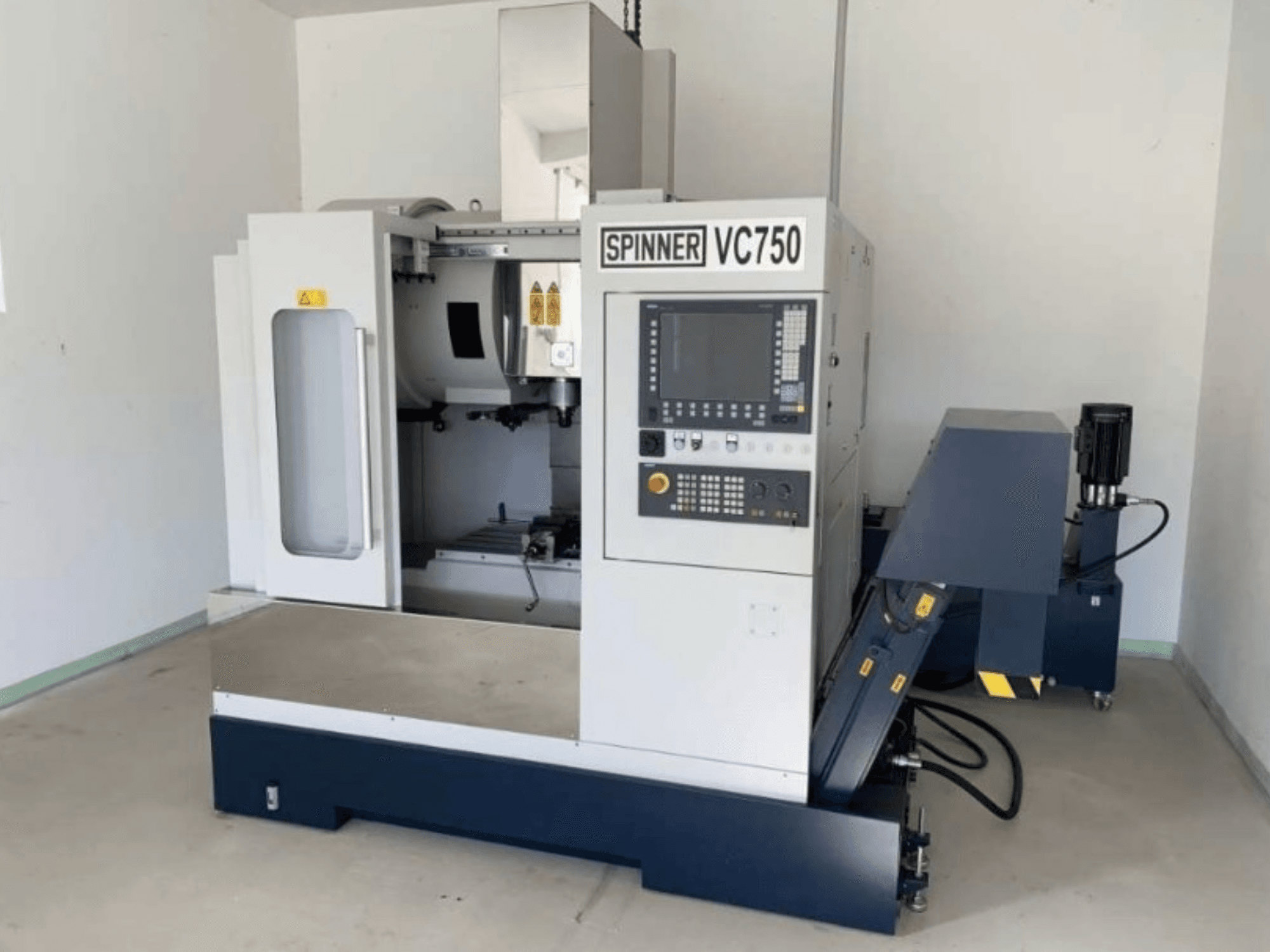 Máquina CNC Spinner VC750 em vista frontal, mostrando o painel de controlo, a área do fuso e os componentes eléctricos.