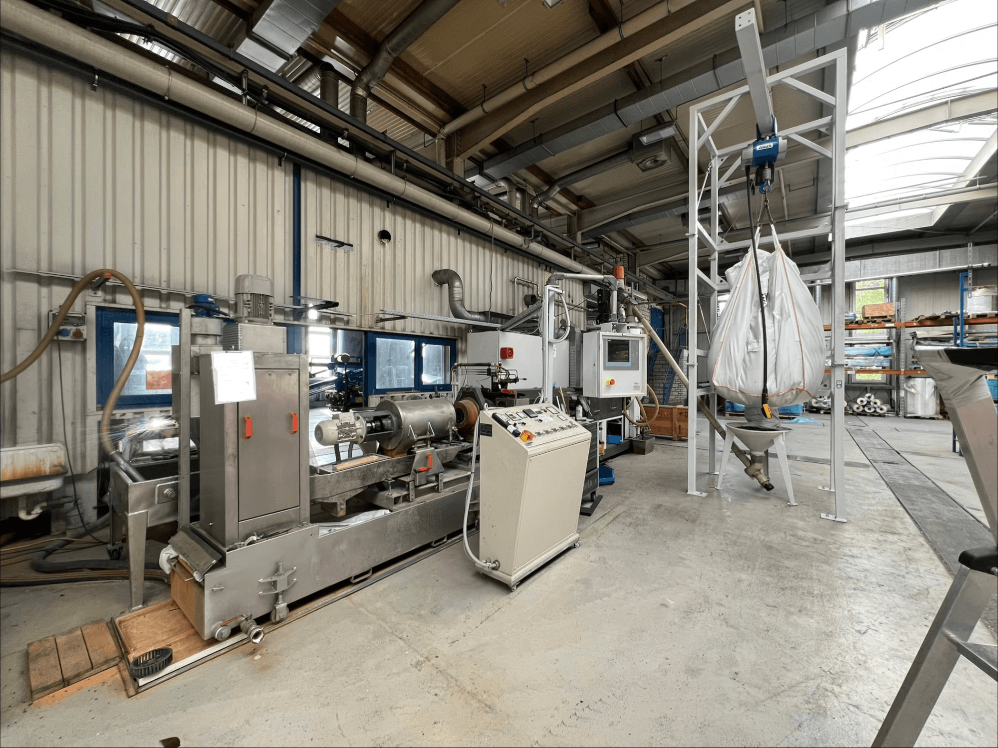 Vista frontal da máquina de processamento de plástico FILTEC GRP 350 num ambiente industrial, apresentando os comandos e o sistema de alimentação.