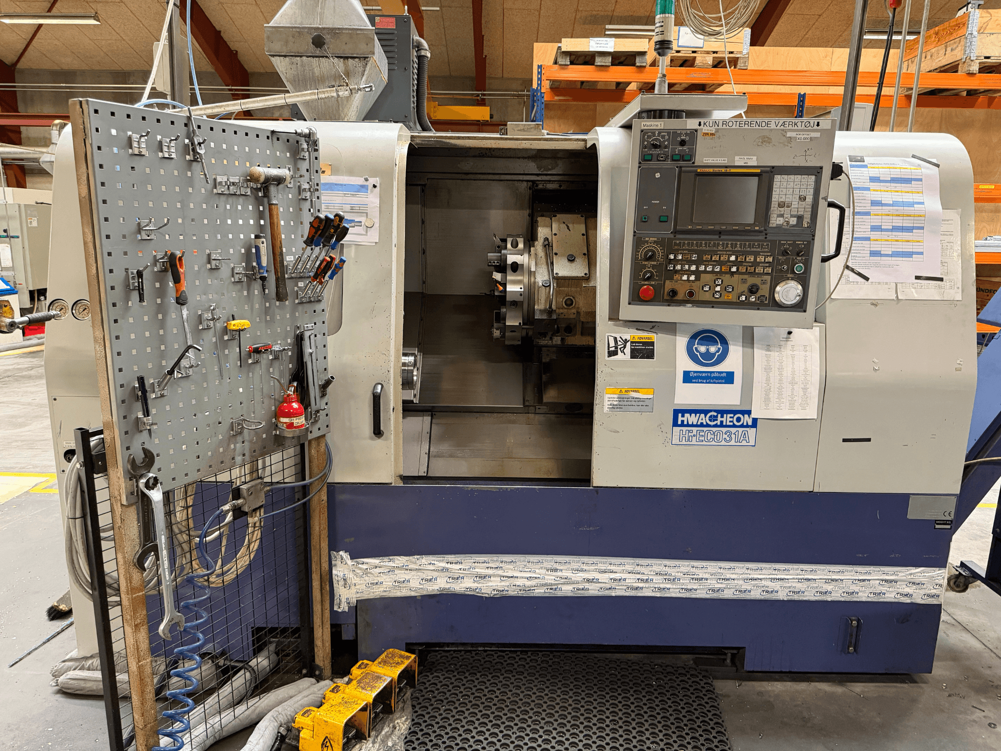 Torno horizontal HWACHEON HiEco-31A com painel de controlo, ferramentas na lateral e visibilidade clara do interior da máquina.