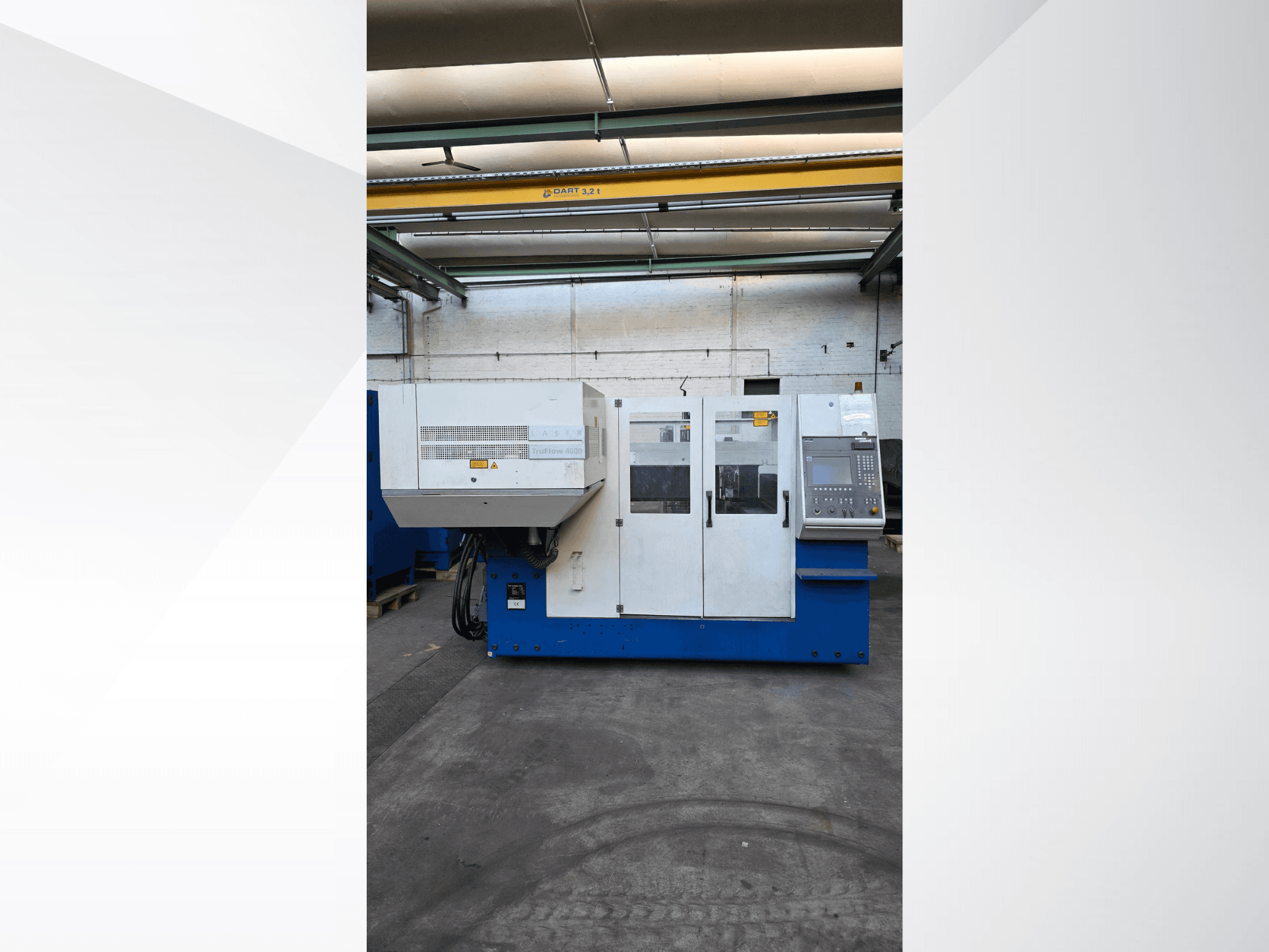 Máquina de corte a laser TRUMPF TruLaser 3030 CO2, vista frontal, com painel de controlo e avisos de segurança no exterior.