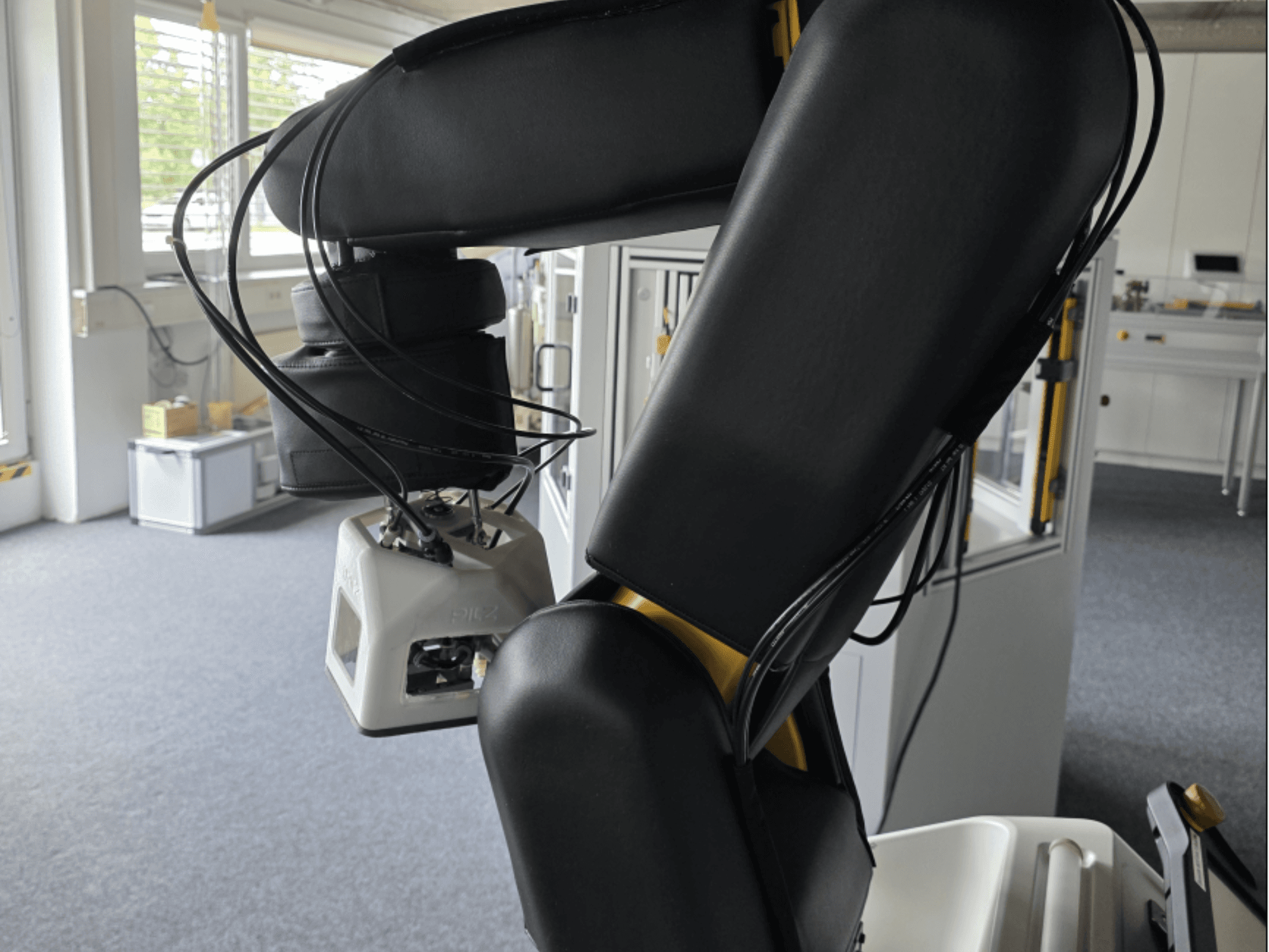 Vista lateral do robô colaborativo FANUC LR Mate 200iD/7L, mostrando o braço e os sensores, com os cabos visíveis num ambiente de oficina.