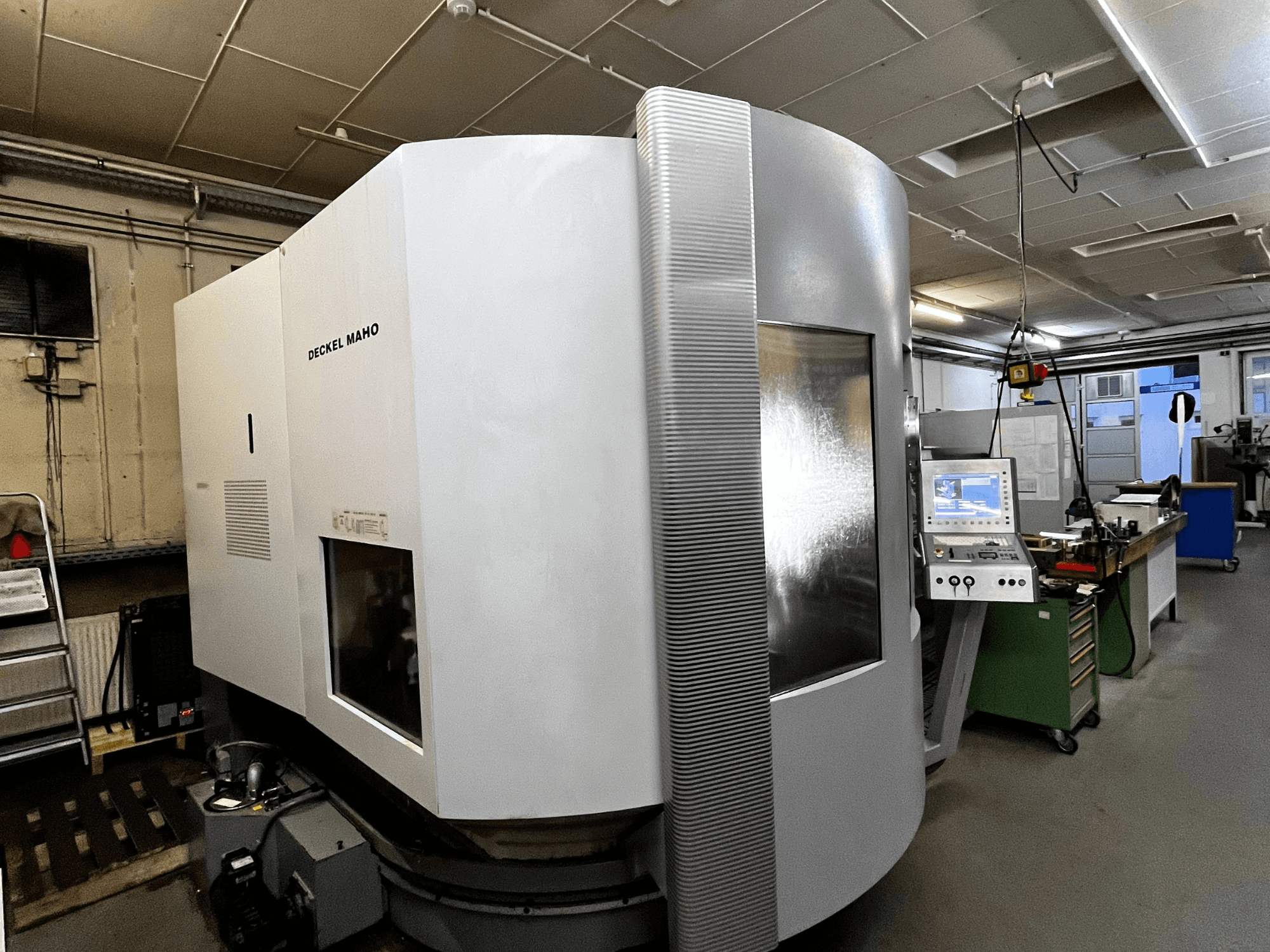 Máquina CNC Deckel Maho, vista frontal, exterior branco, painel de controlo visível, configuração de oficina.