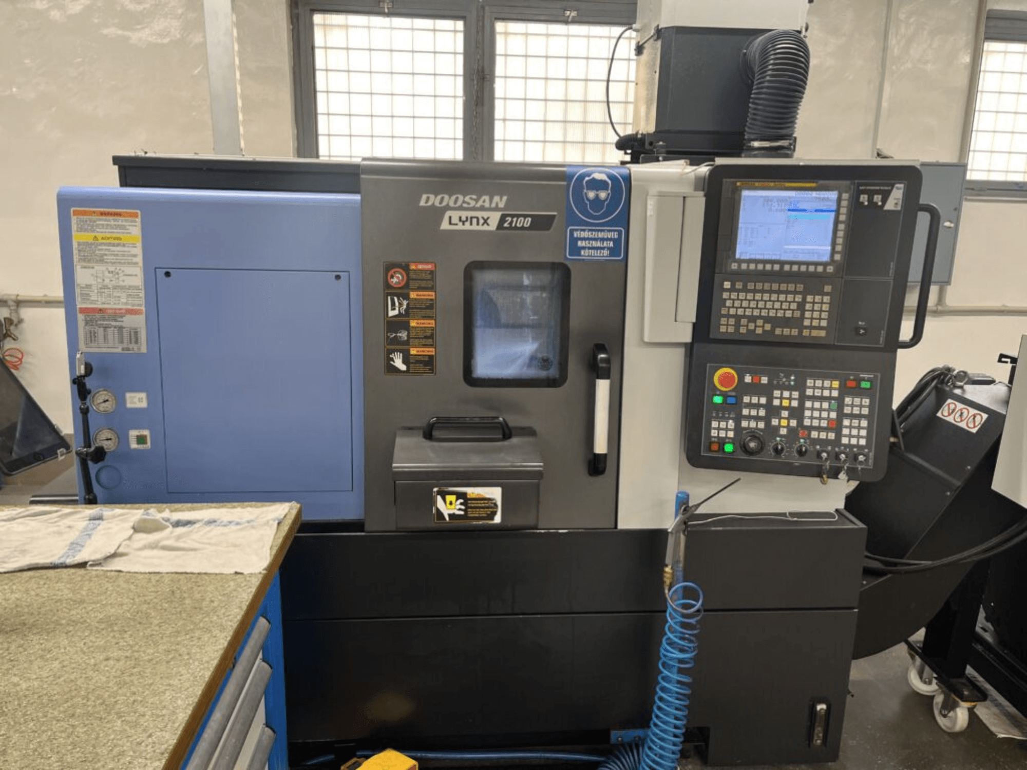 DOOSAN Lynx 2100A, virador horizontal, vista frontal mostrando o painel de controlo, a interface do operador e as caraterísticas da máquina.